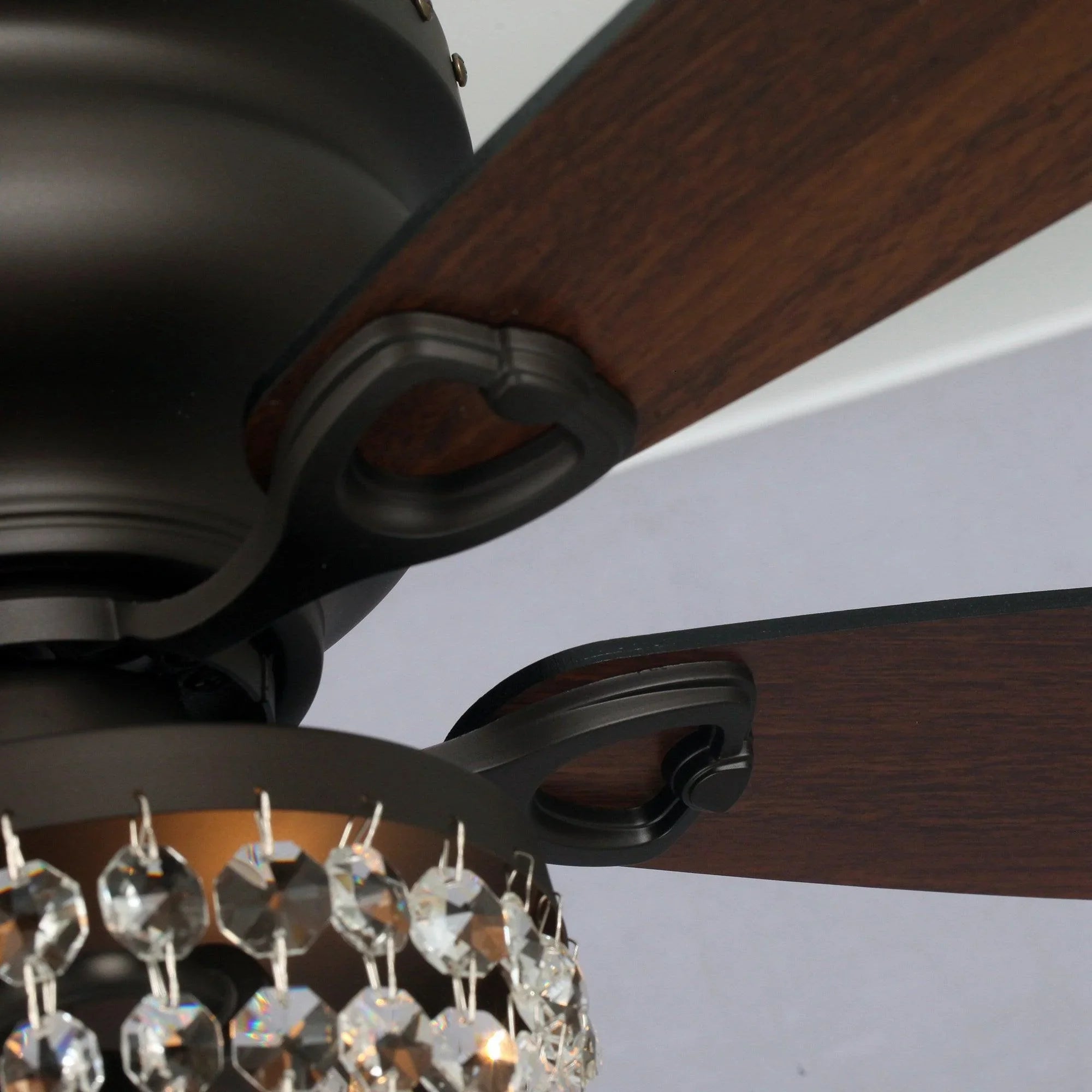 Ceiling fan blade bracket detail with dark wood-style blade and black flush motor