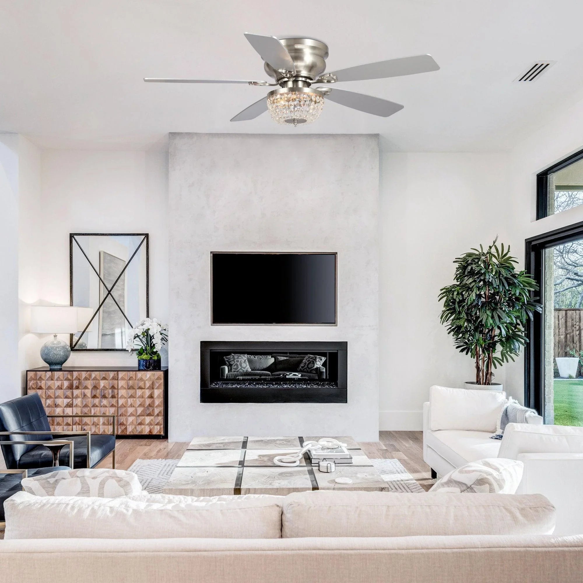 Brushed nickel flush-mount ceiling fan with crystal light centered in living room ceiling