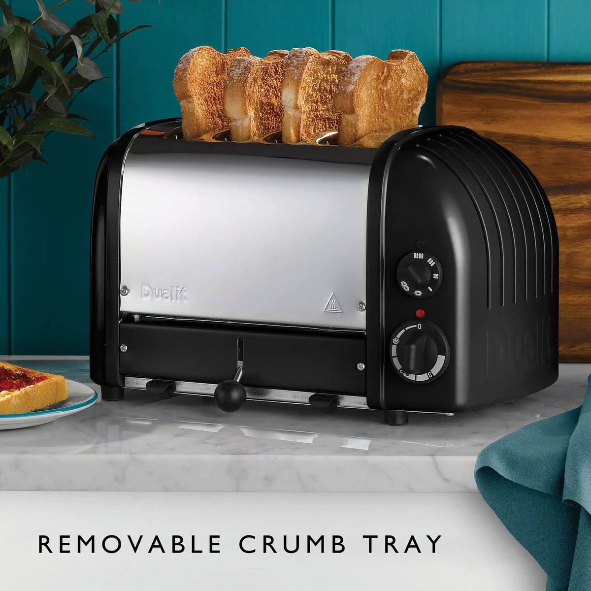 Dualit 4-slice NewGen toaster in matte black with bread slices on the warming rack