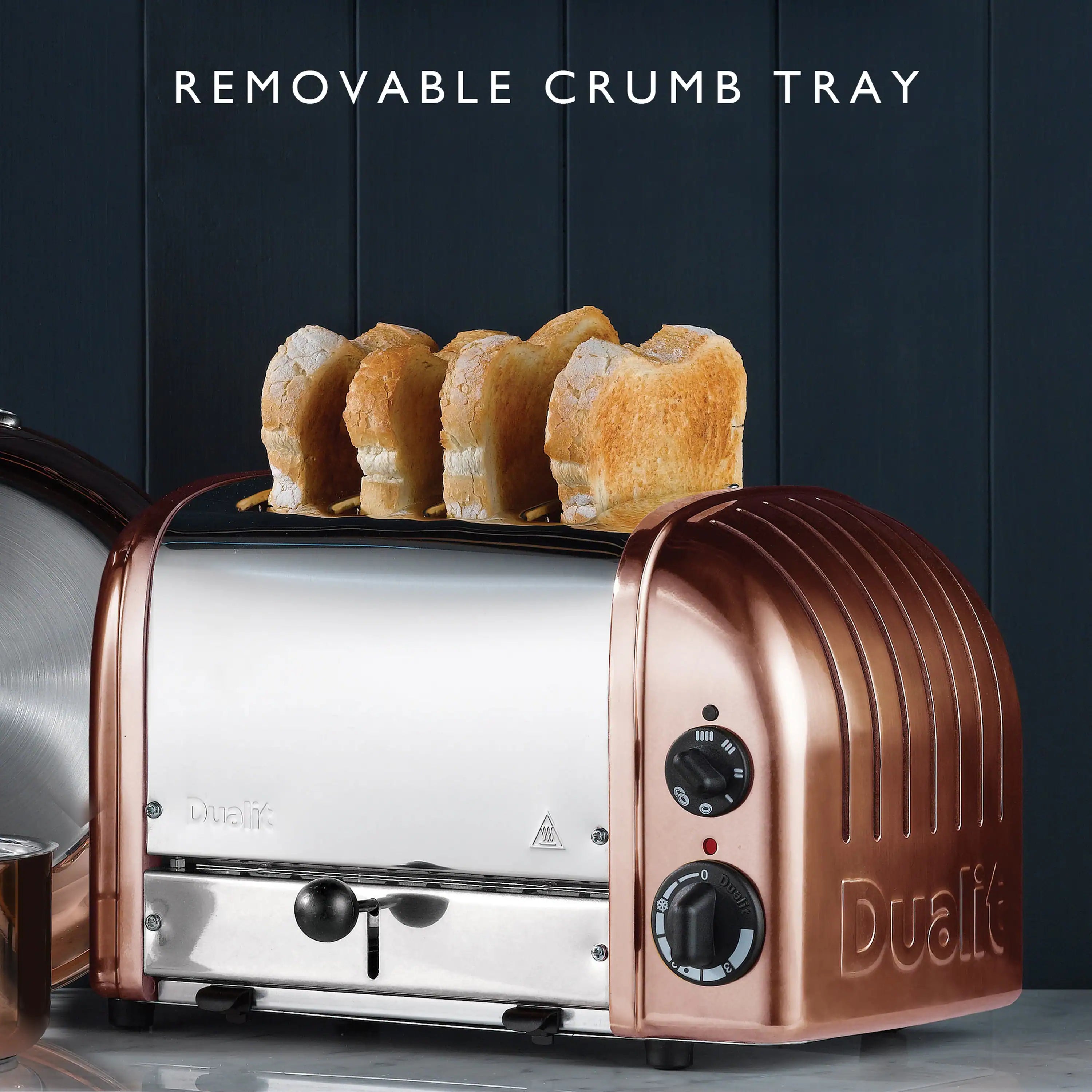 Copper and white Dualit 4-slice toaster with bread on the crumb tray area
