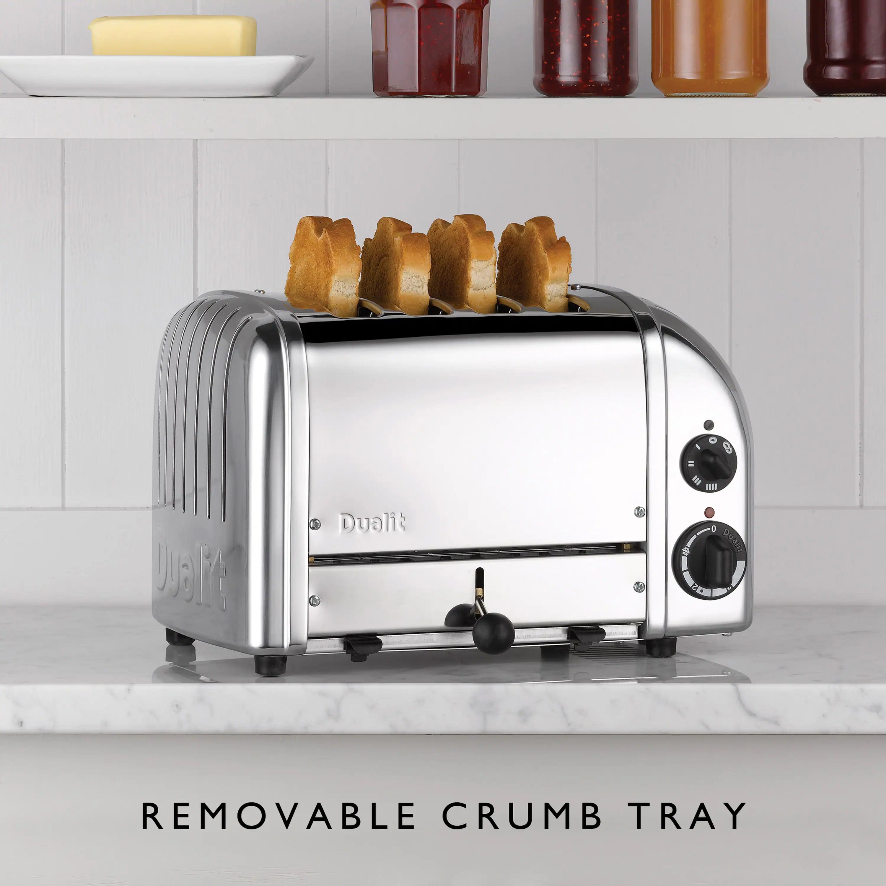 Dualit 4-slice chrome toaster with toast rising and removable crumb tray shown