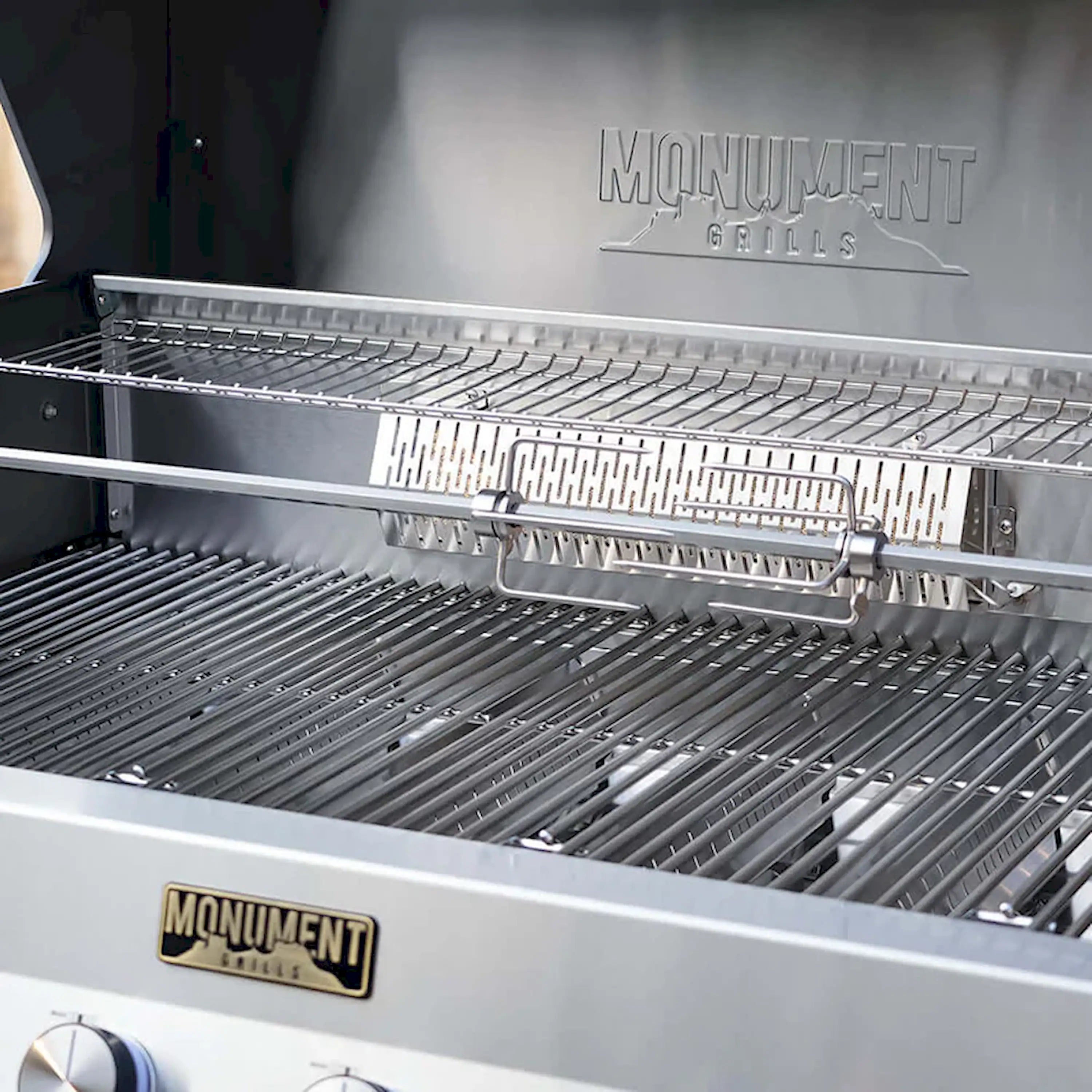 Open grill with stainless cooking grates and side warming rack inside Monument