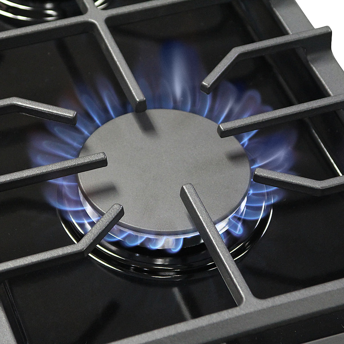 Black gas cooktop burner with metal grate and visible blue flame
