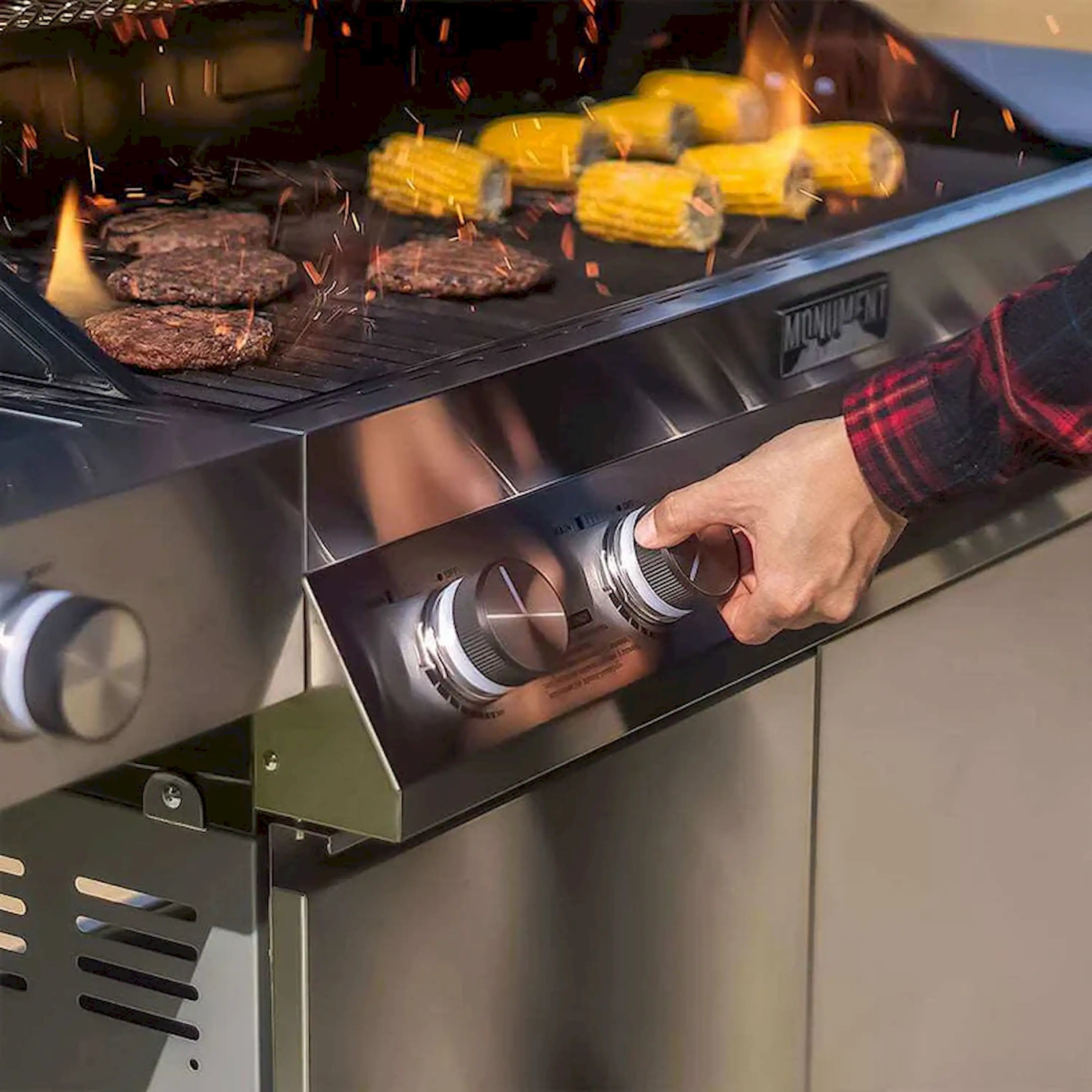 Stainless gas grill interior with lit burners and cooking food