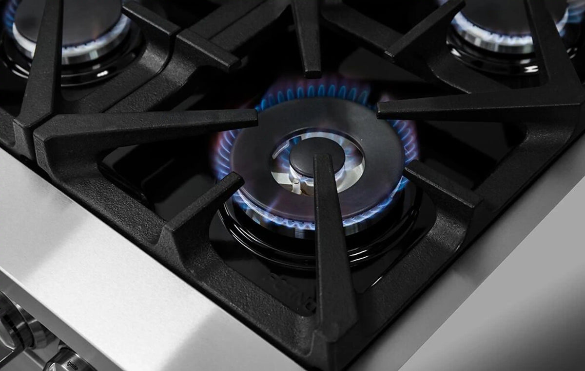 Dual fuel cooktop burner with blue flame under a black grate