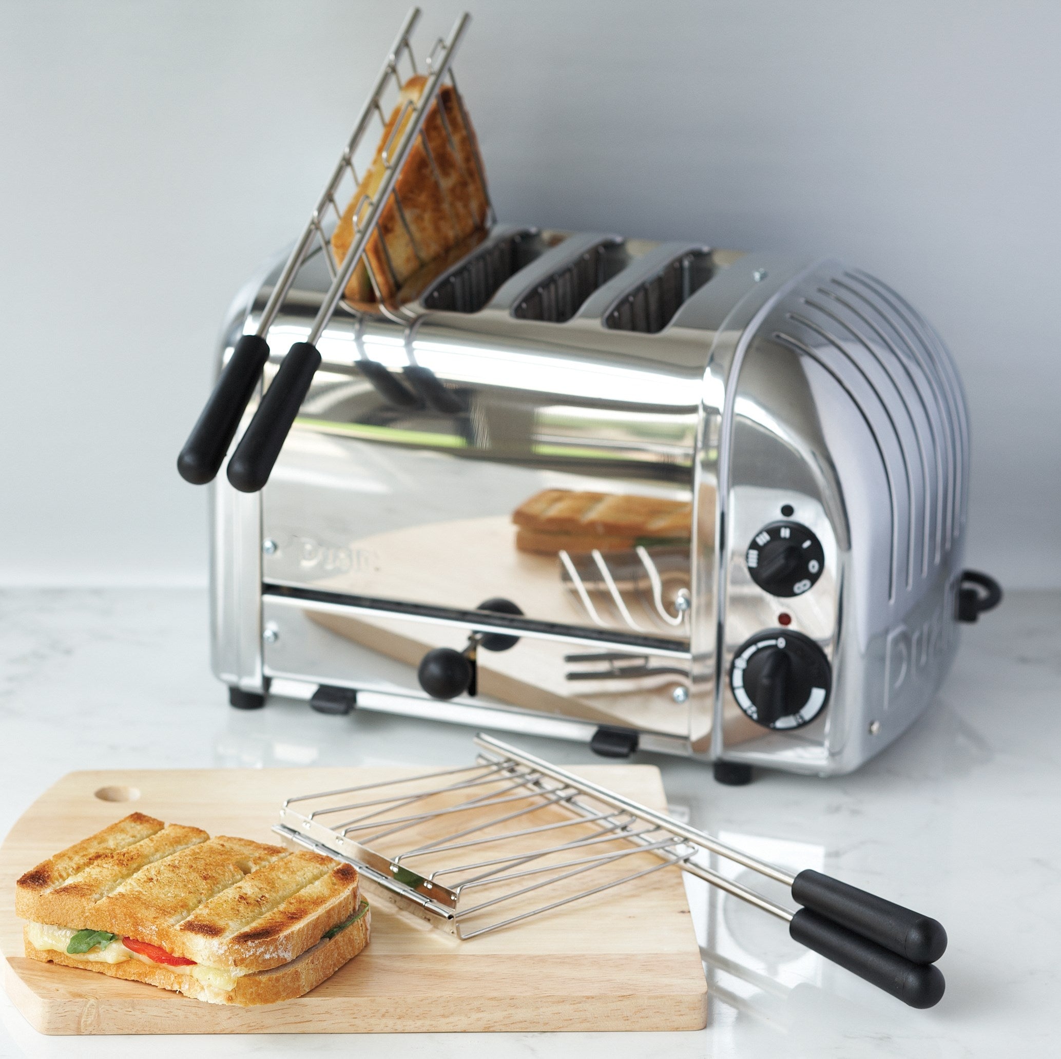 Chrome sandwich toaster in side view with browning controls and cooking rack