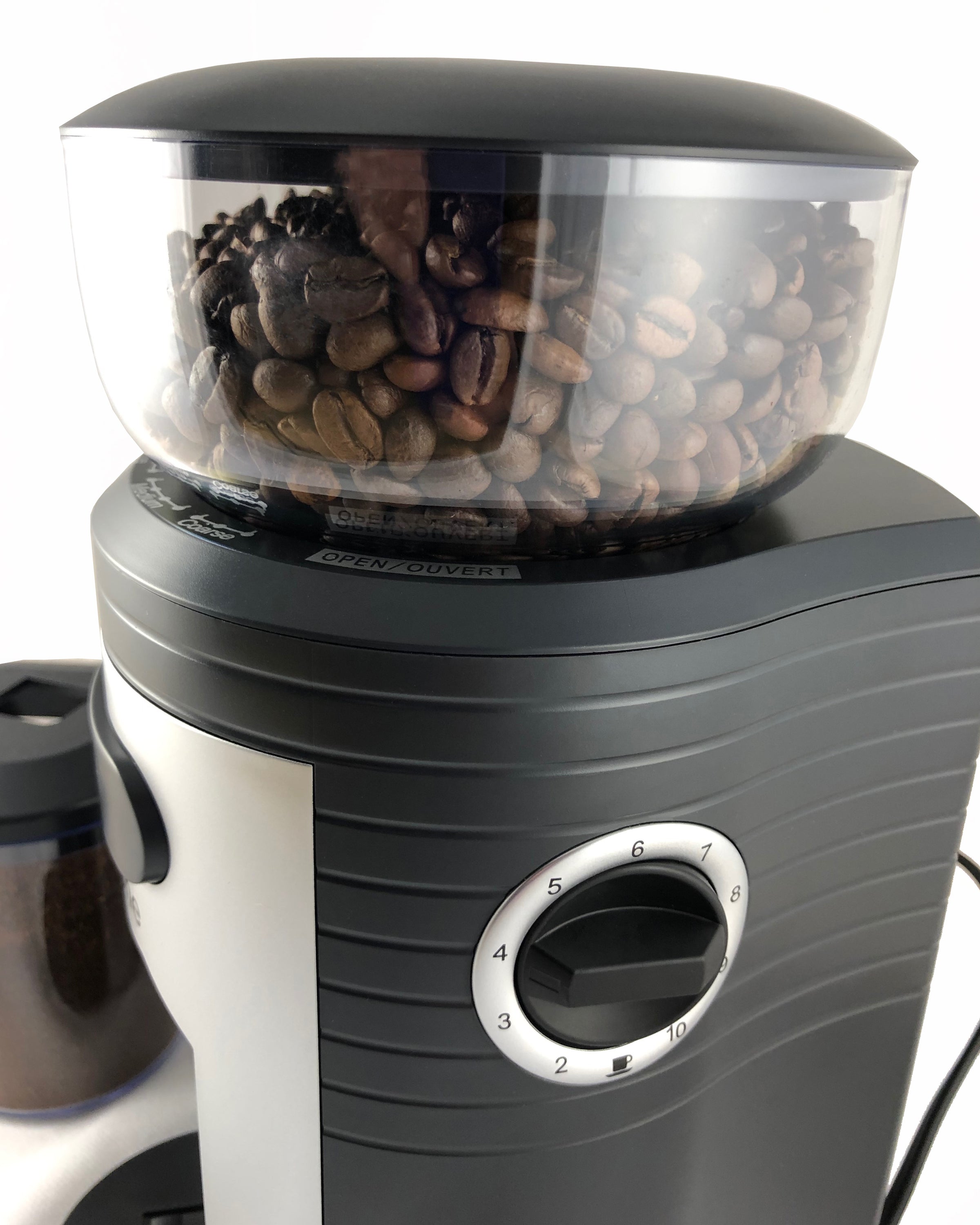 Close-up of conical burr coffee grinder dial with numbered settings on black and silver body