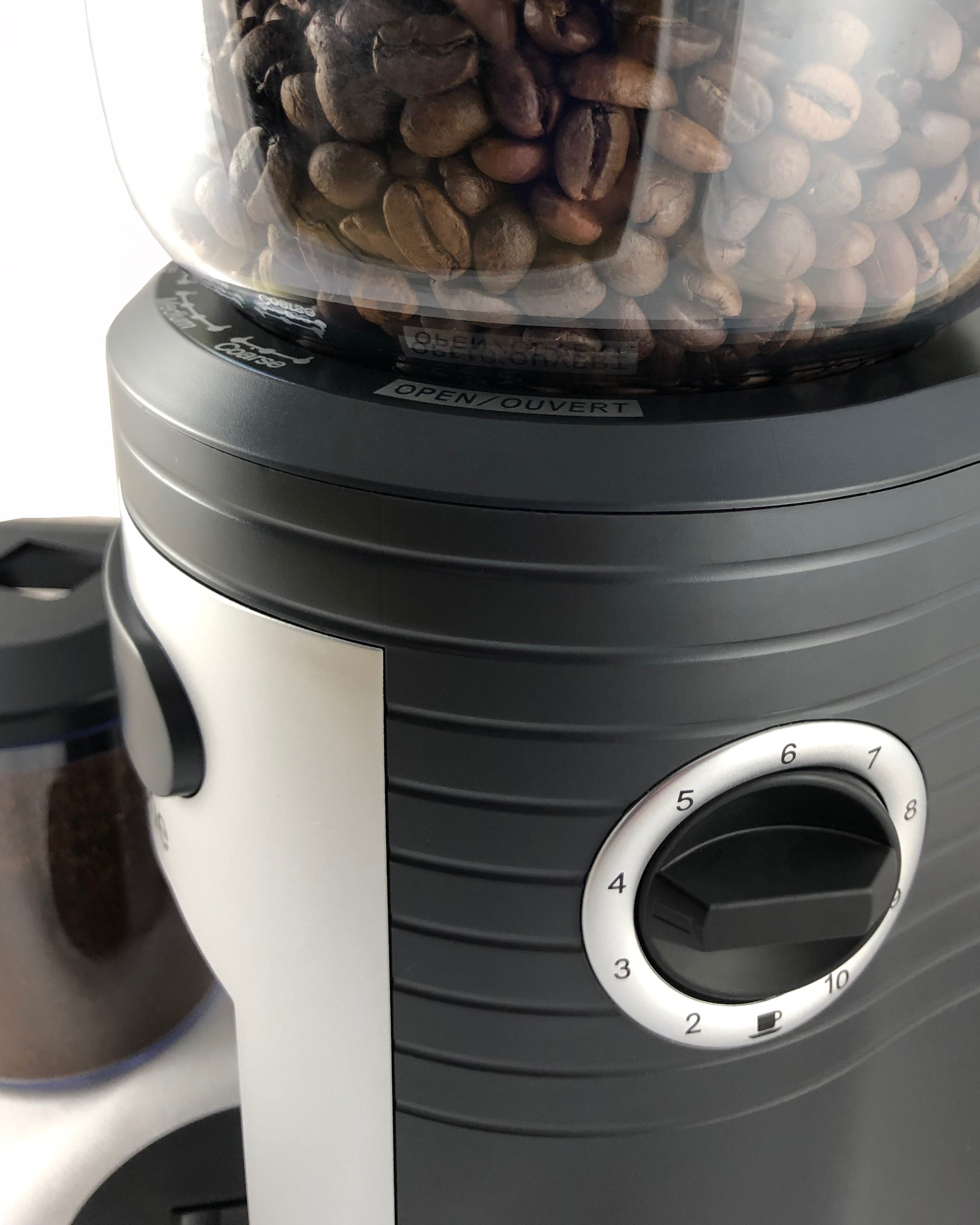 Side close-up of conical burr grinder with open/close markings and numbered dial