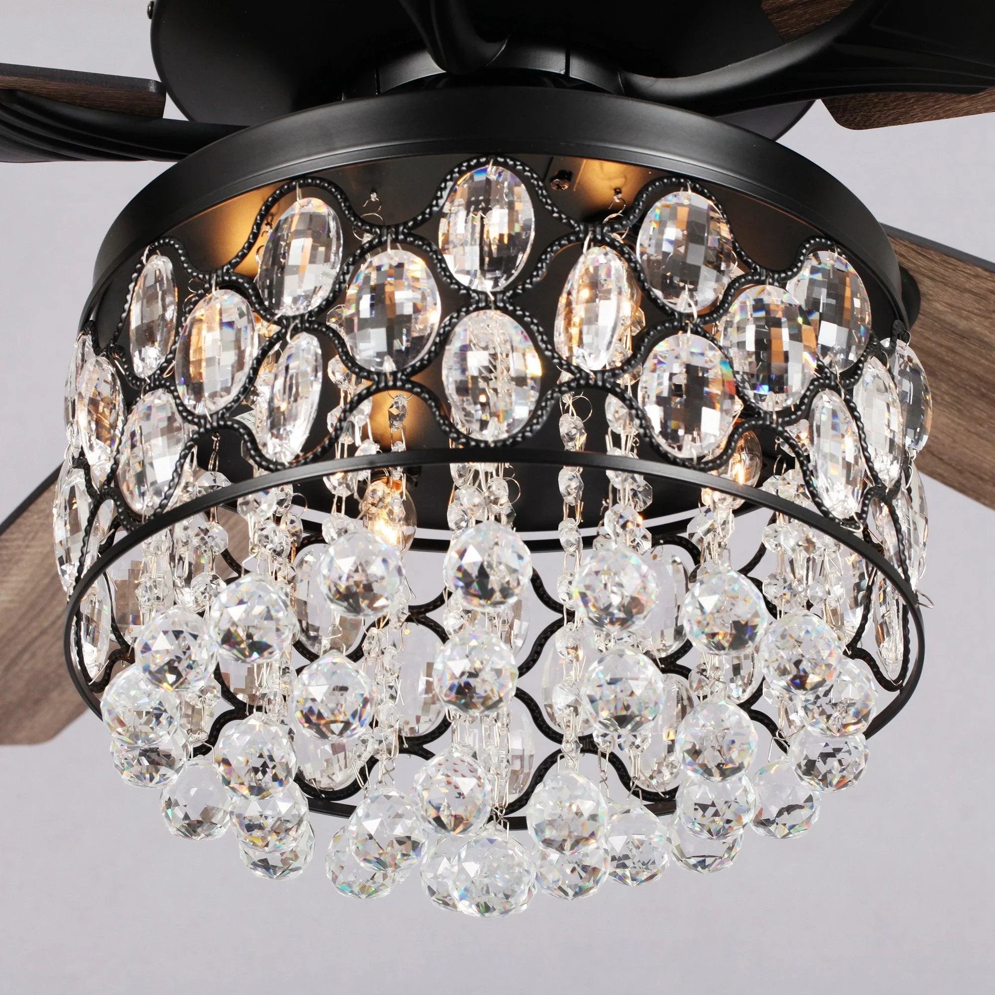 Black ceiling fan light housing with faceted crystal shades and hanging prisms