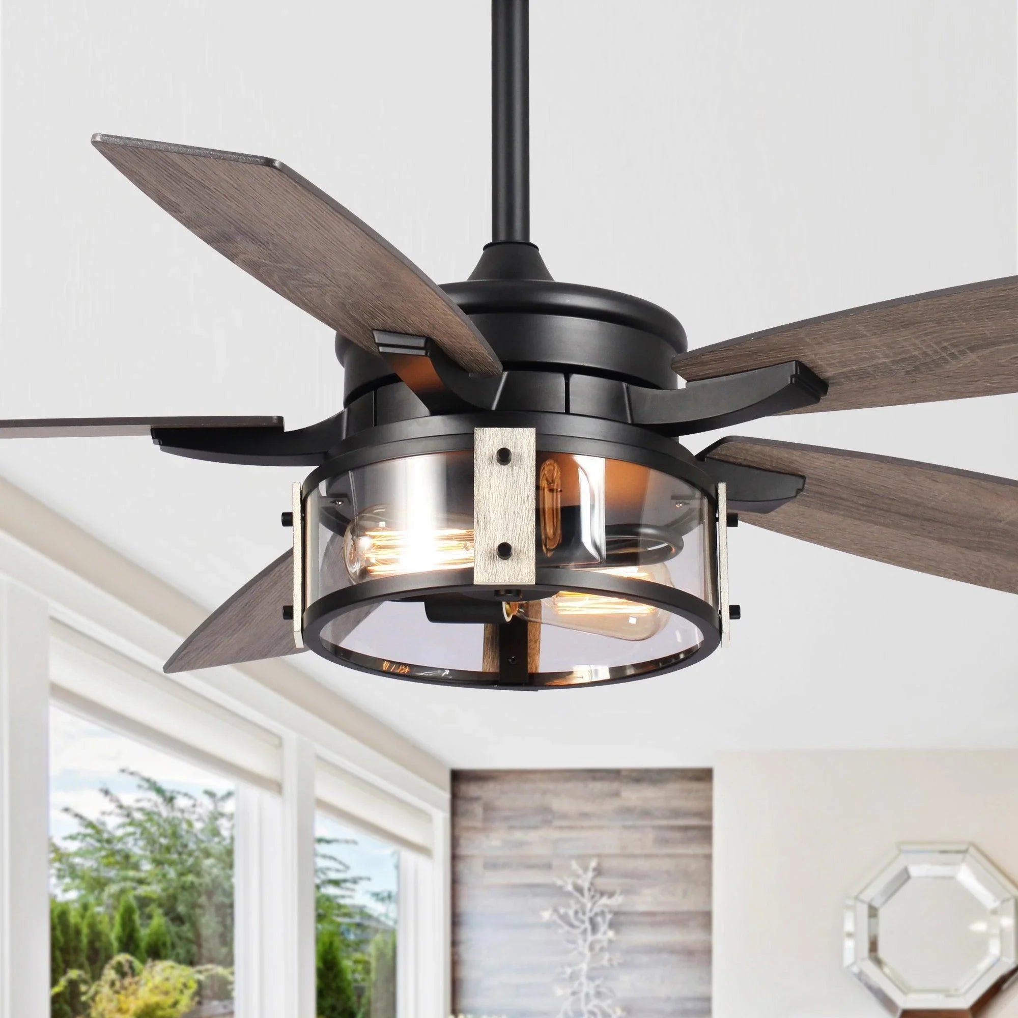 Close-up of black ceiling fan light kit with wood-look blades and glass panels