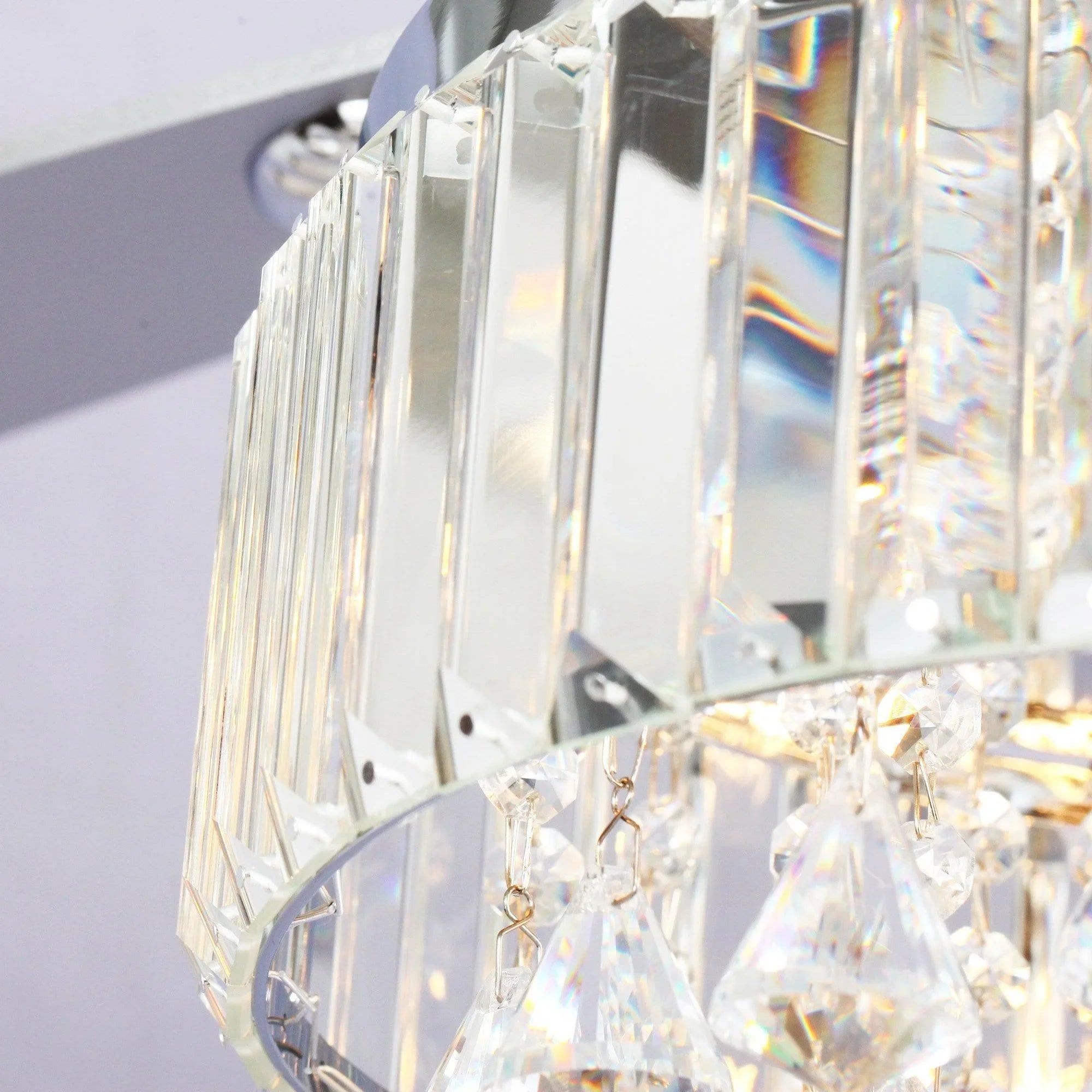Crystal prism drops hanging from chrome fandelier frame, close-up detail.
