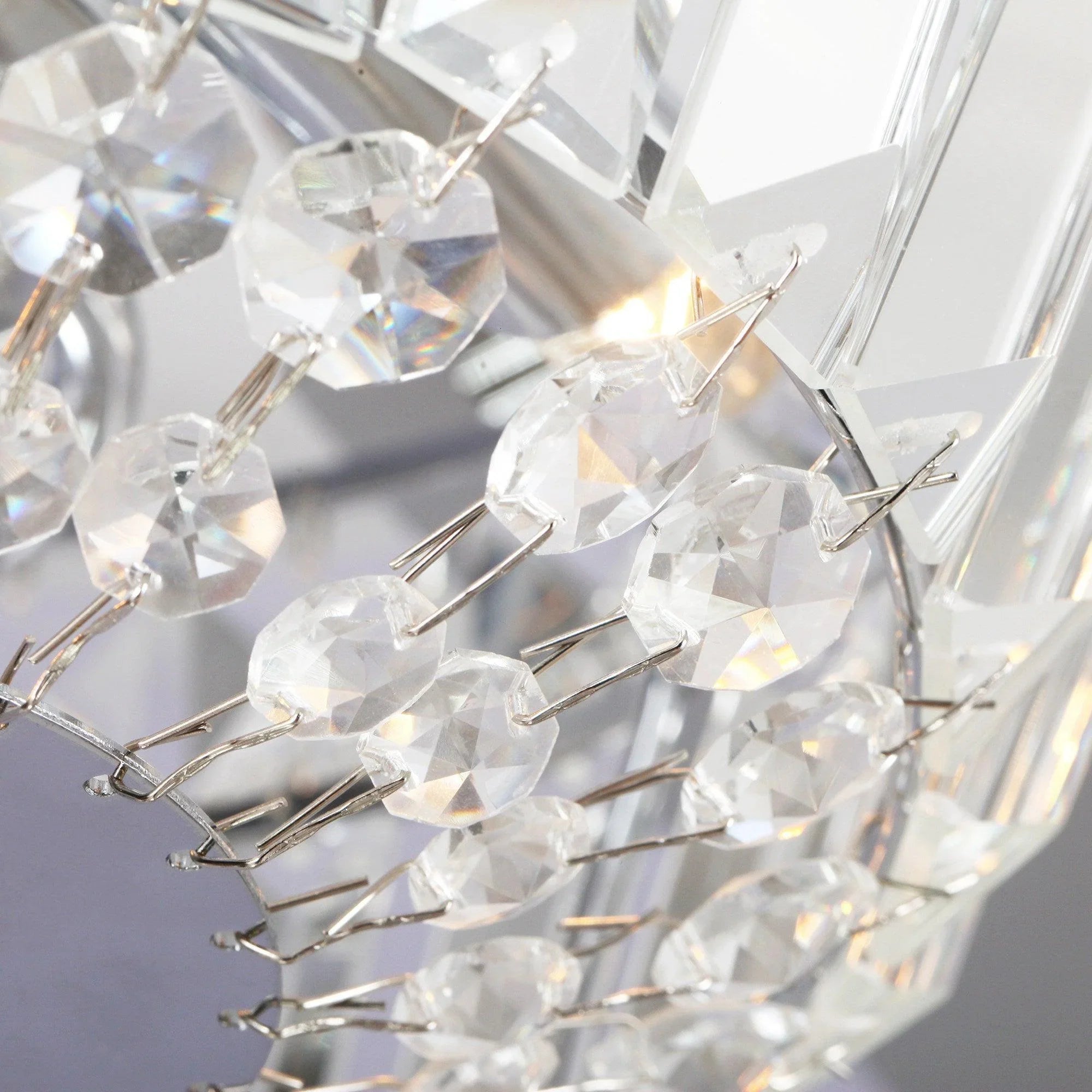 Close-up of faceted crystal prisms and metal arms on the fan light