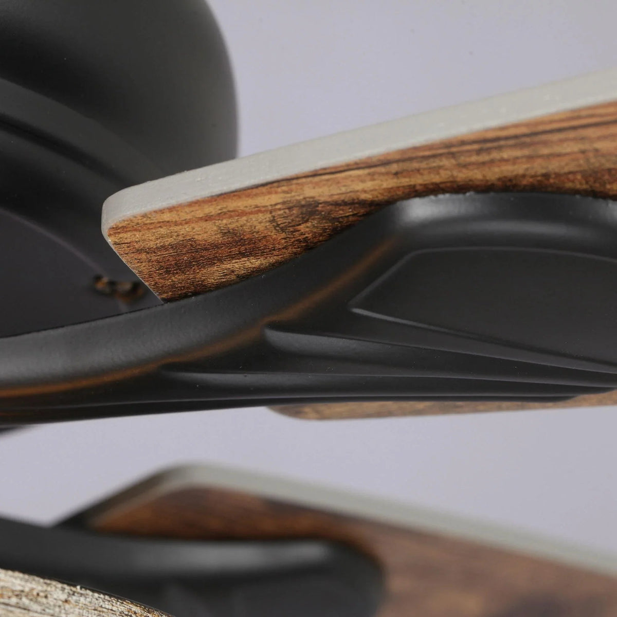 Black ceiling fan blade arm and reversible wood blade with visible wood grain