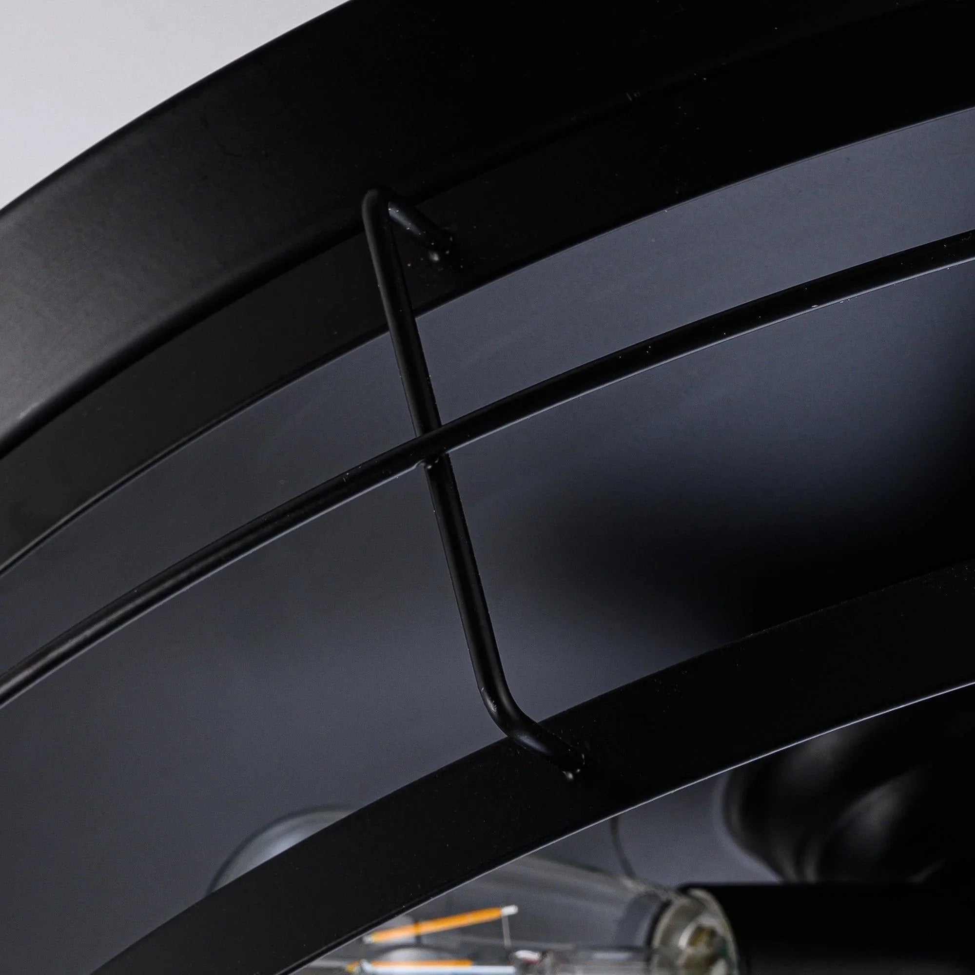 Black fan blade arm bracket with curved metal bars connecting to blade hub