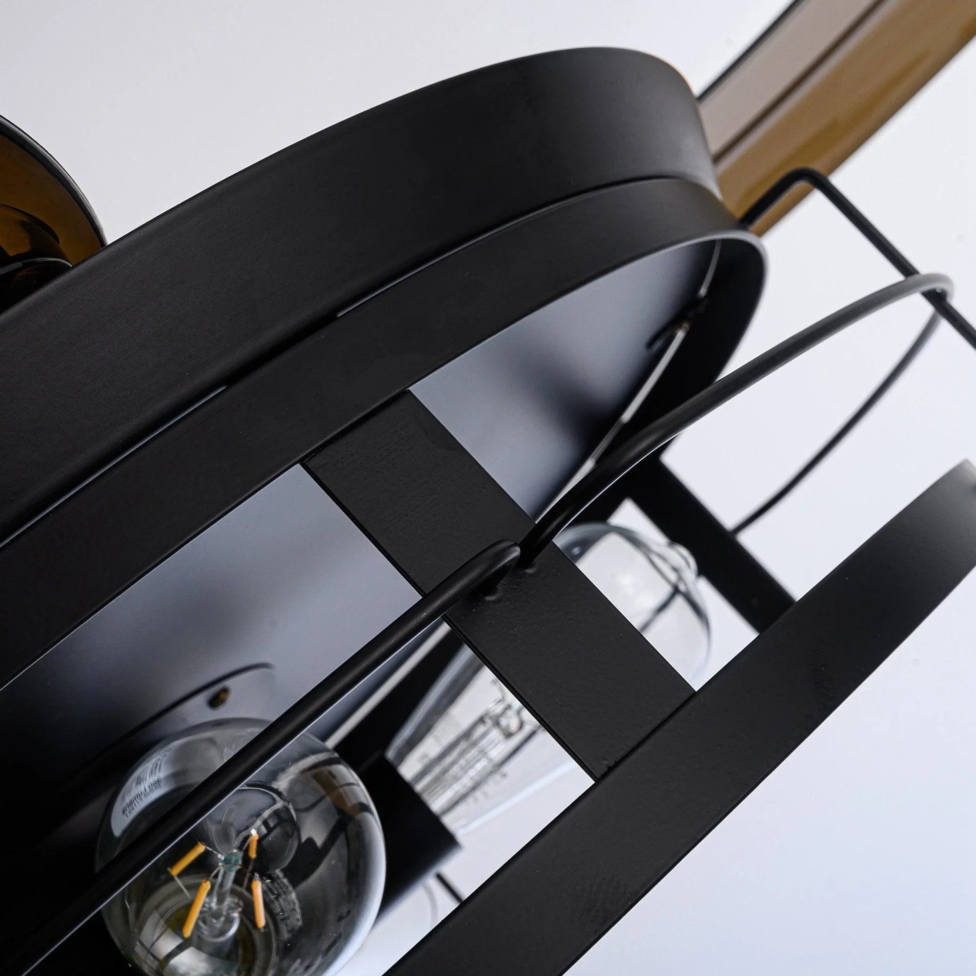Black ceiling fan motor housing with clear glass bulbs under the light ring