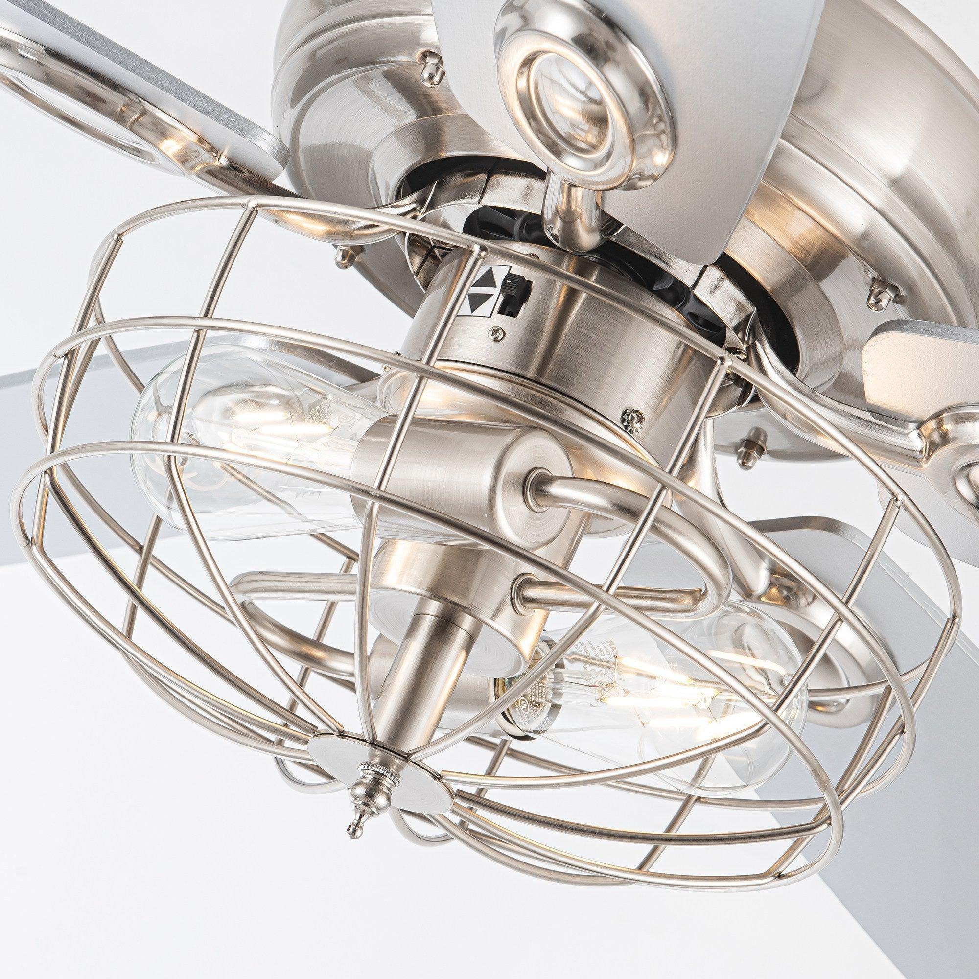 Brushed nickel caged light fixture with glass shades and wiring around the bulb area
