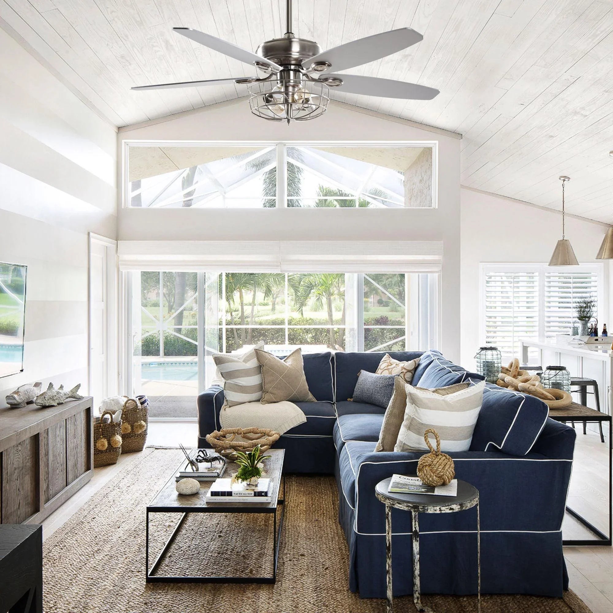 Brushed nickel caged ceiling fan with light and five pale blades in a living room.