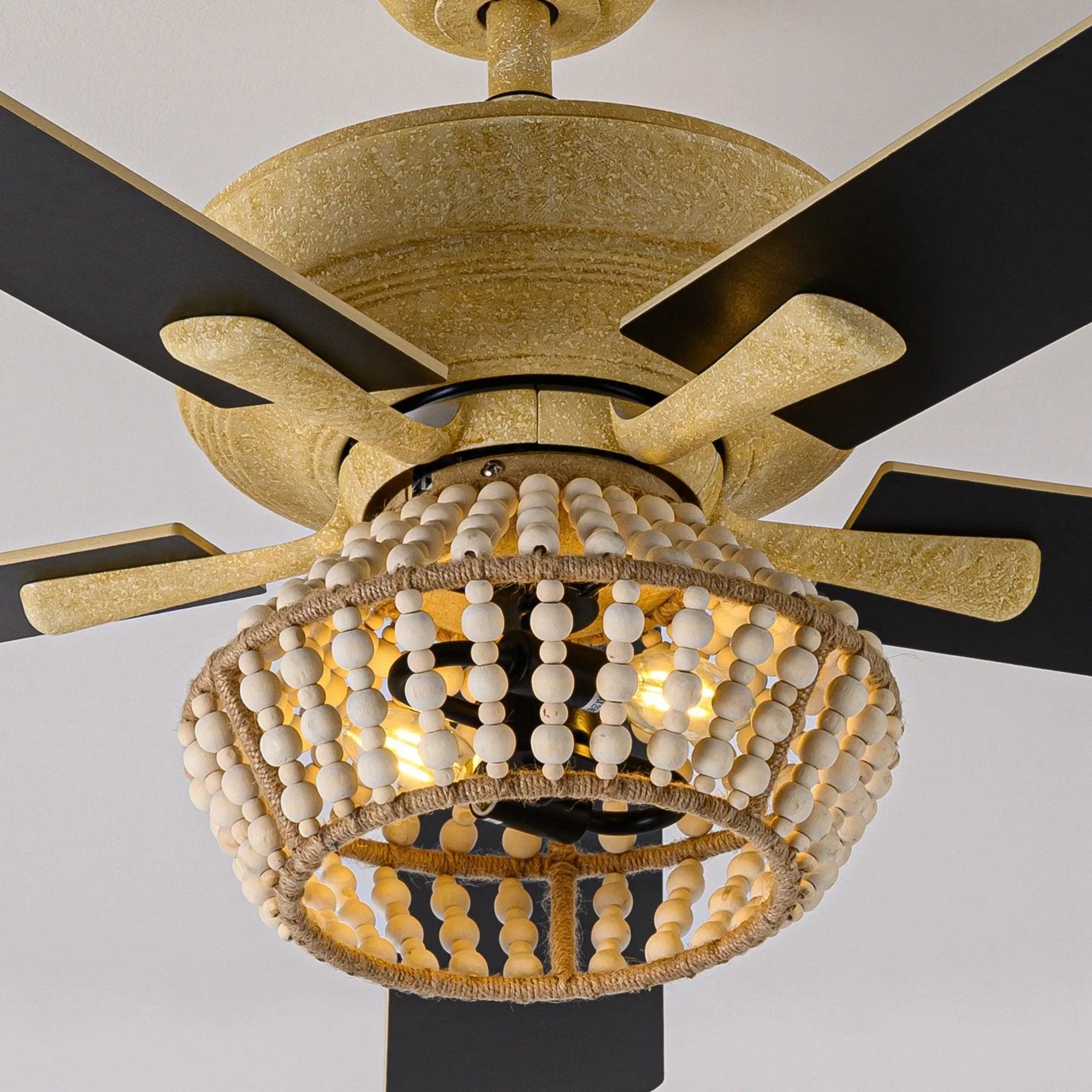 Golden ceiling fan with 5 blades, center fan motor, and lit globe light shade