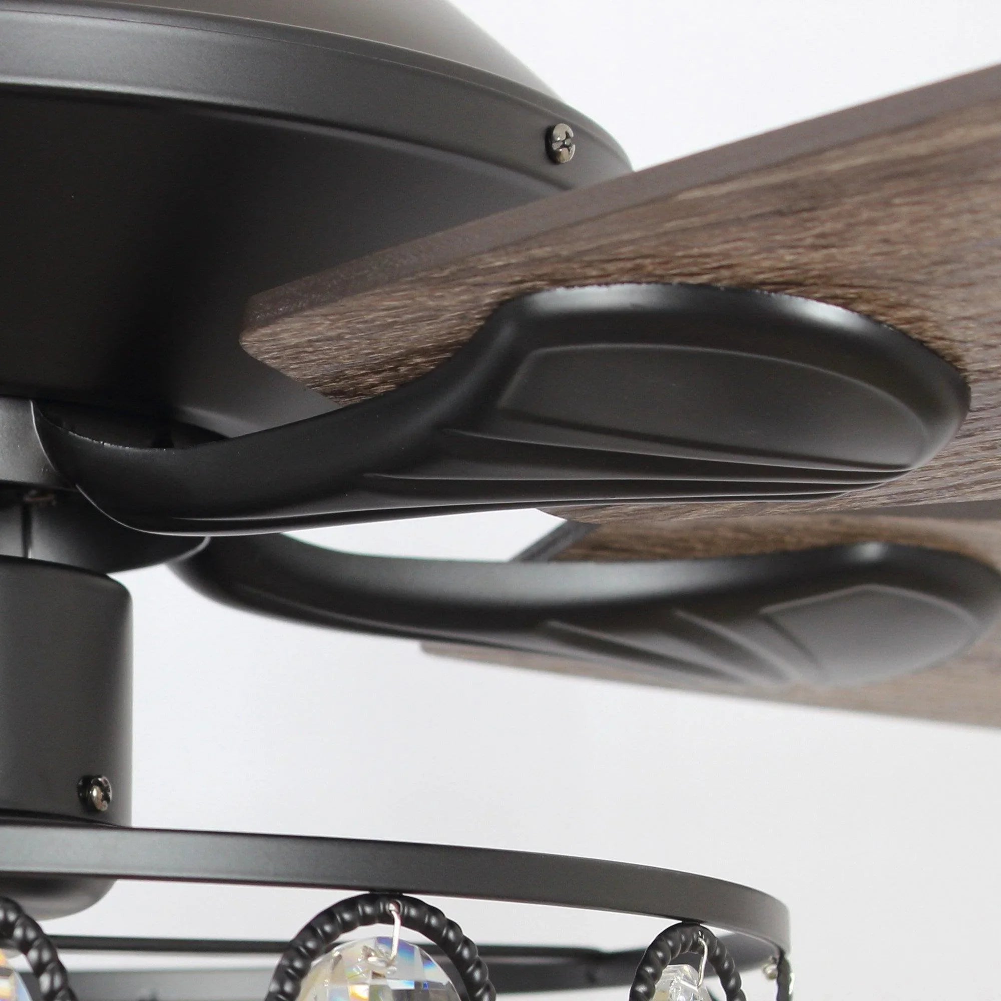 Black ceiling fan blade and housing close-up above the crystal light ring