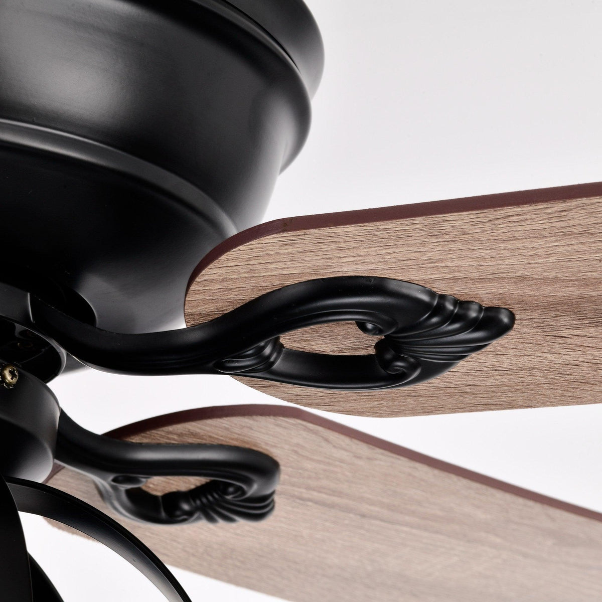 Black ceiling fan blade arm with wood-toned reversible blade