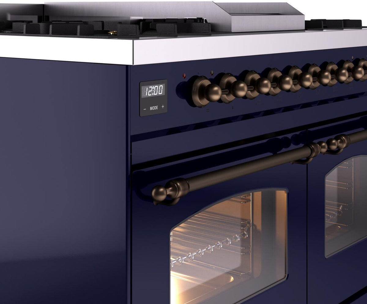 Midnight blue dual fuel range control panel with knobs and display above a lit oven door