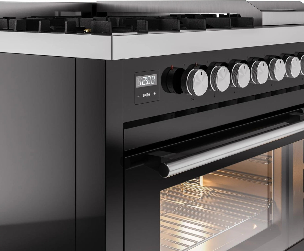 Black dual fuel range control knobs and lit oven window beneath the cooktop.