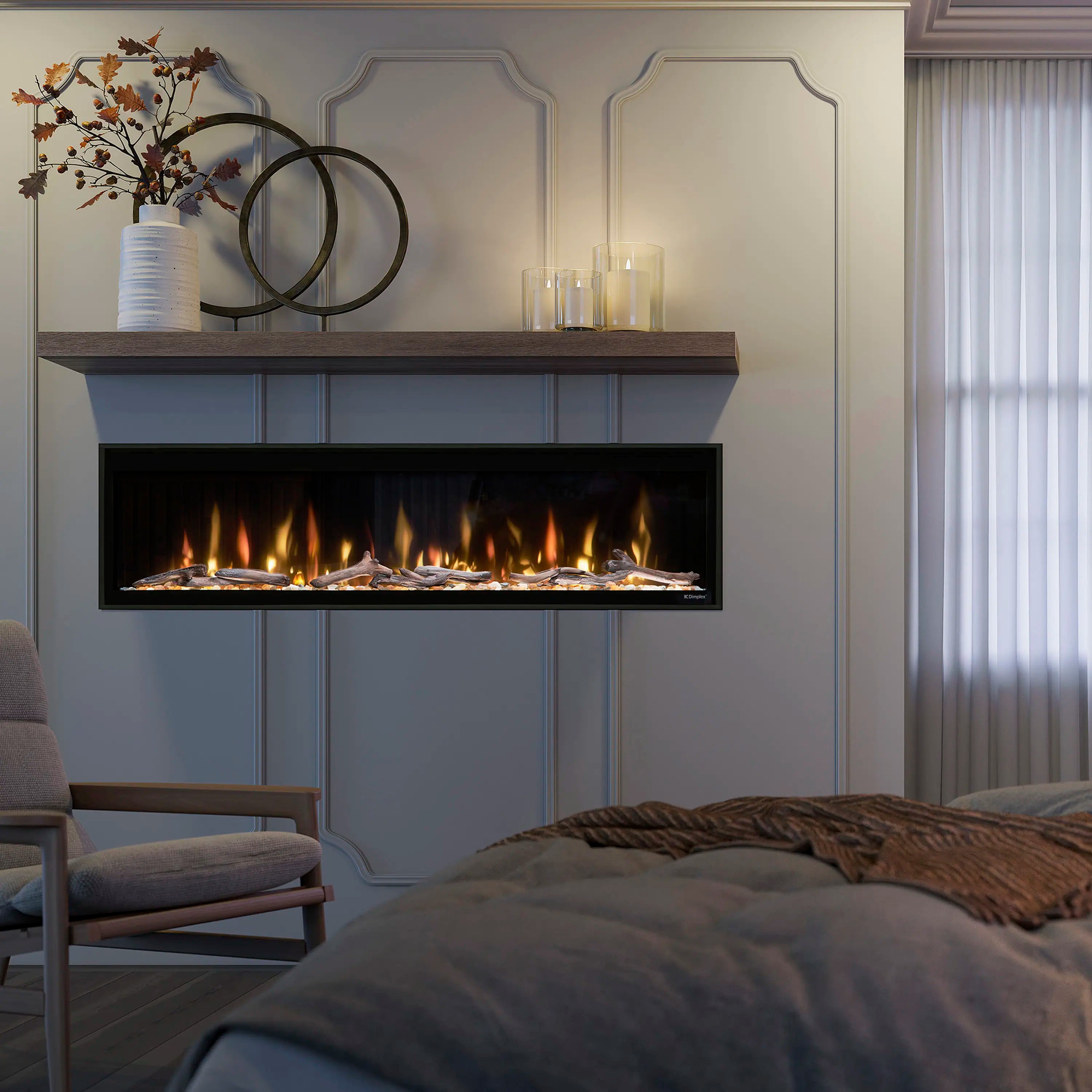 Linear electric fireplace in black frame with orange flame effect over faux logs