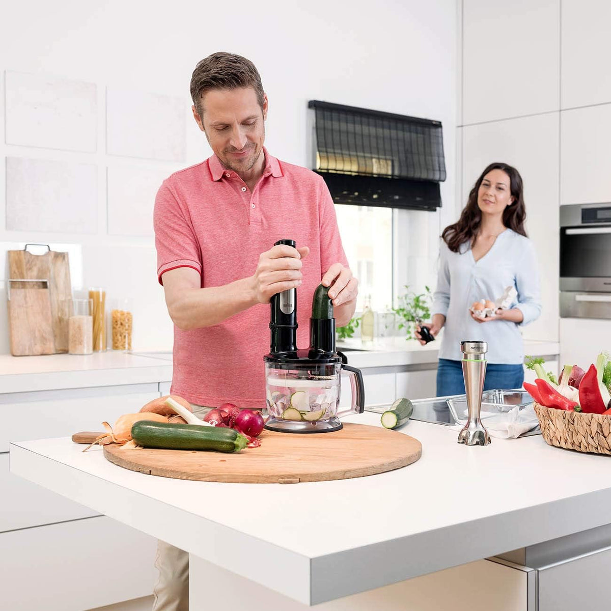 Braun stainless steel hand blender in a chopper bowl with mixing attachments