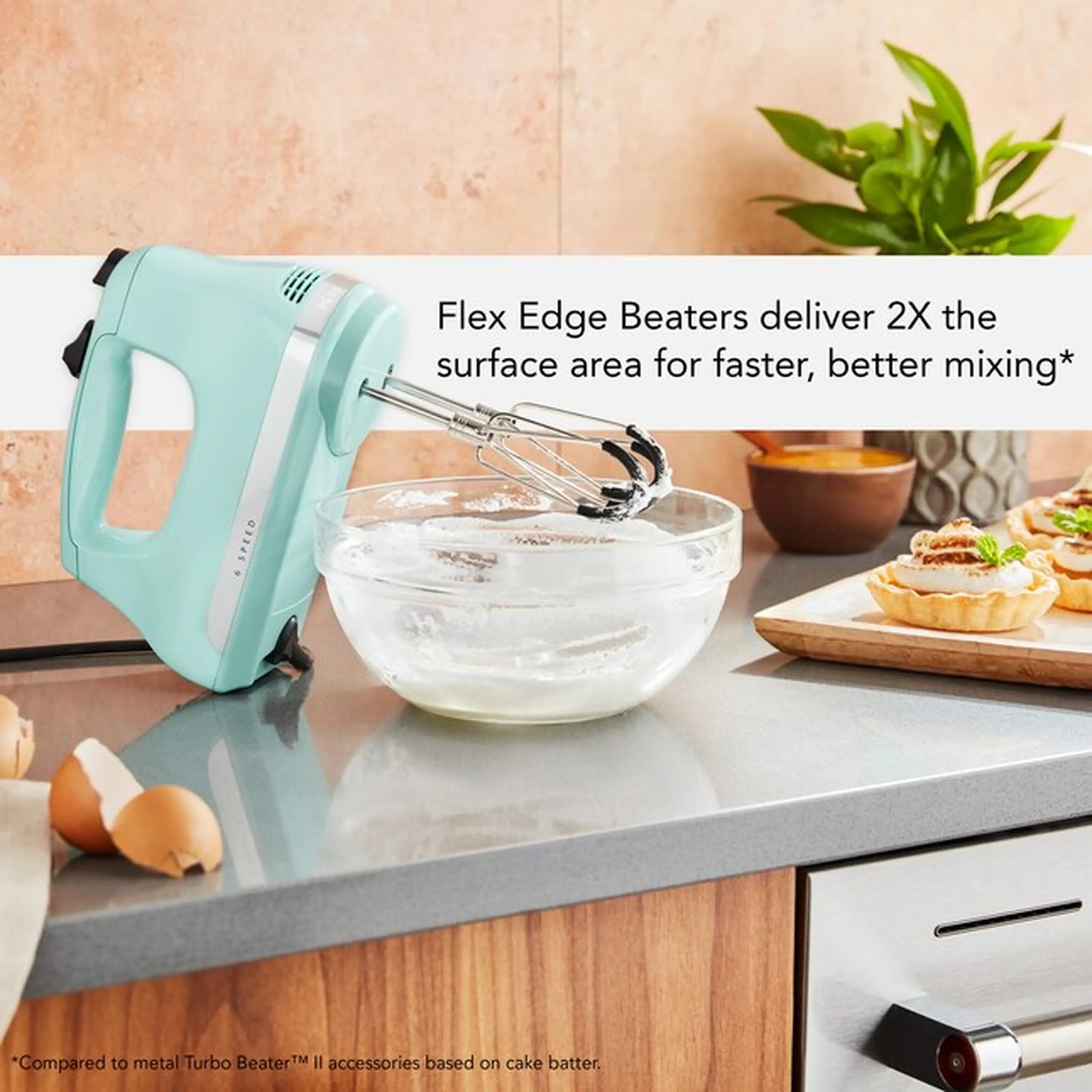 Ice blue hand mixer with wire beaters in a clear mixing bowl