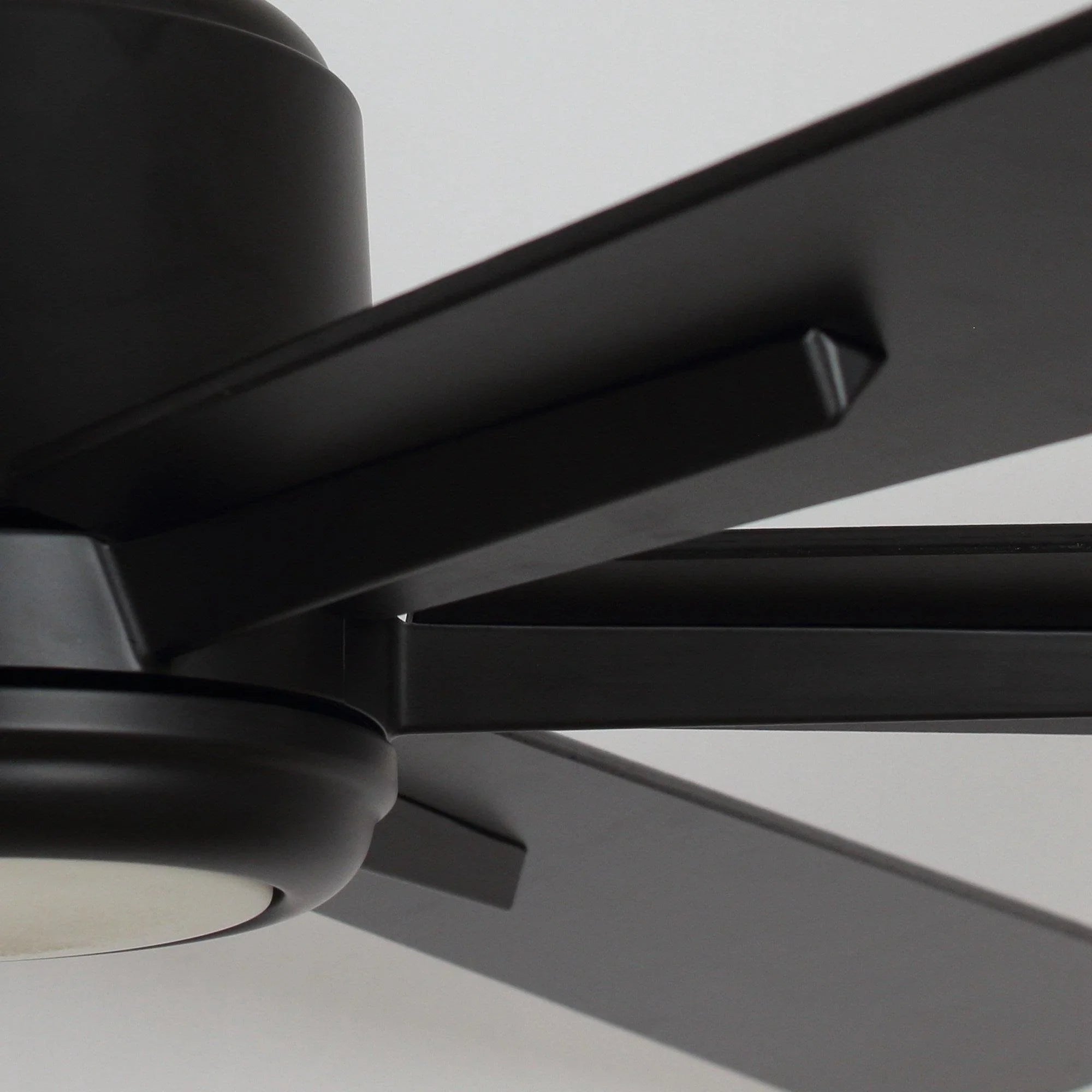 Close view of black ceiling fan blades and central motor housing