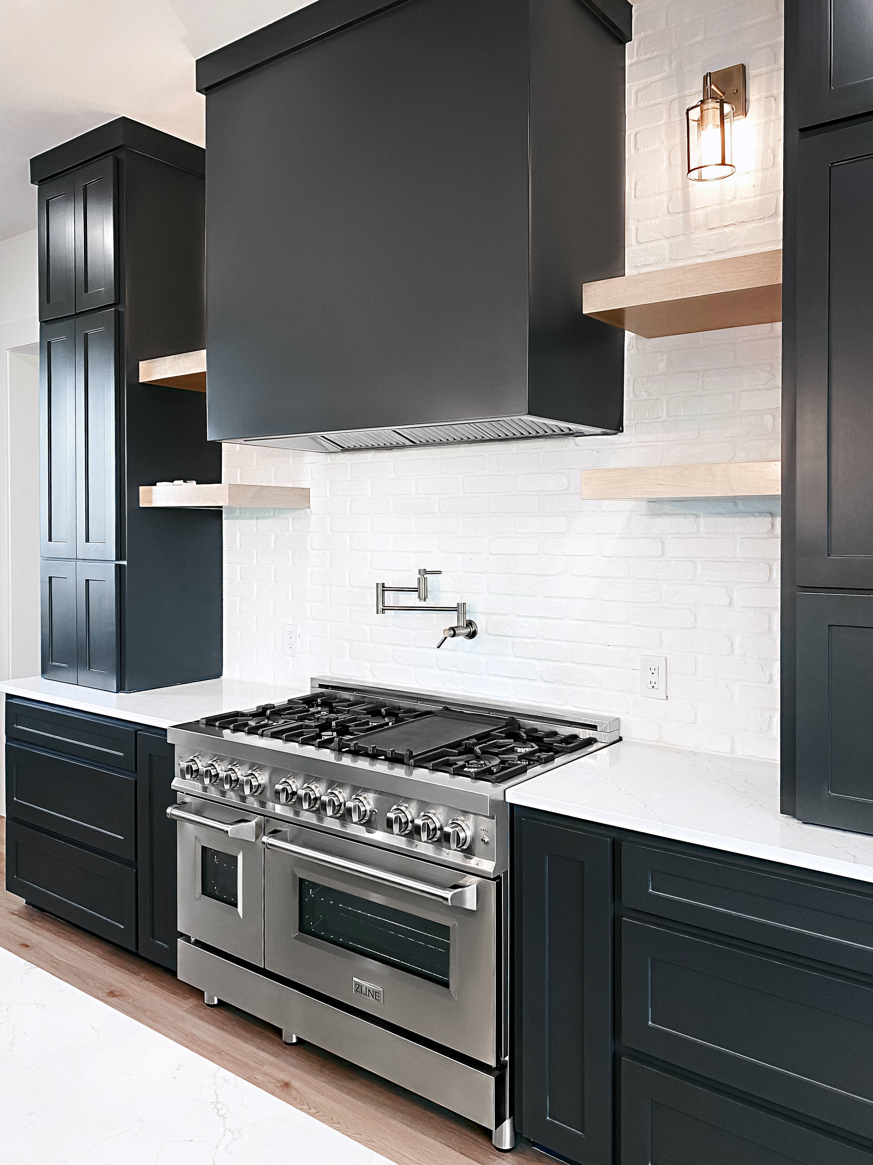 Stainless steel dual-fuel range with black cooktop grates and oven door