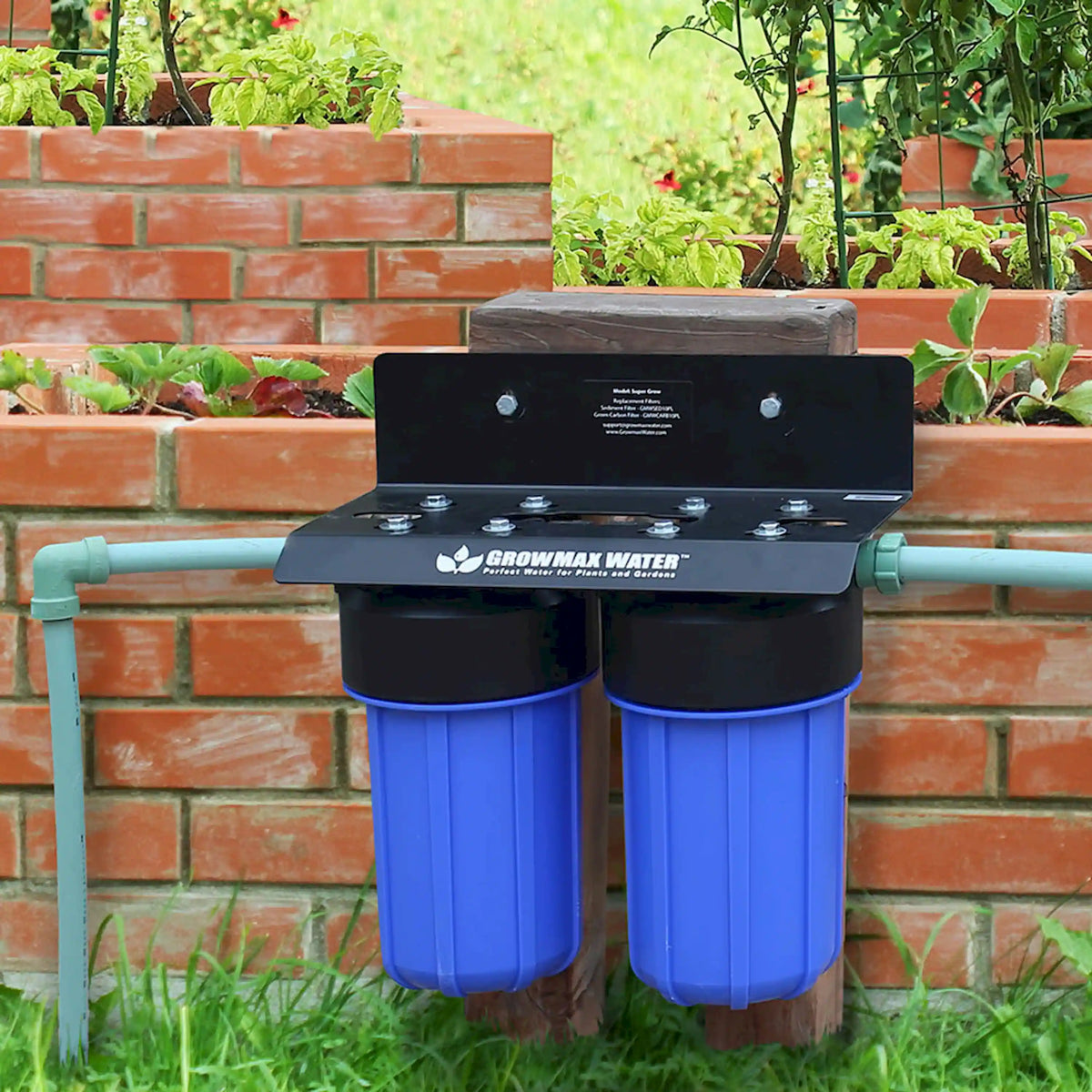 Garden water filtration system with black housing and two blue filter canisters