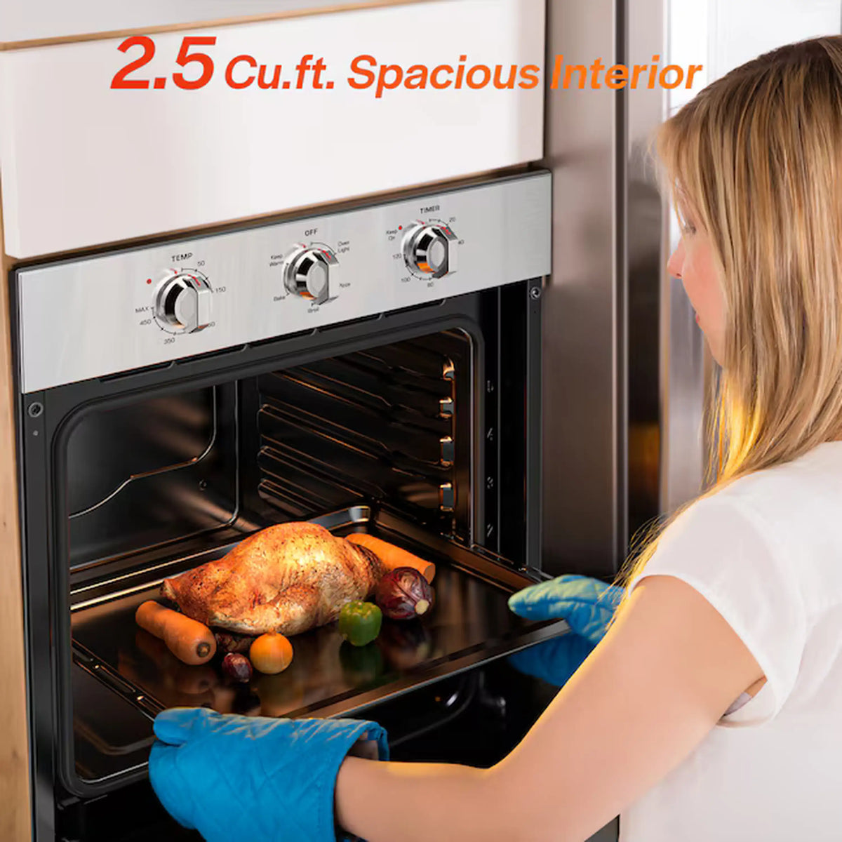 Stainless steel wall oven with glass door open and person placing food inside