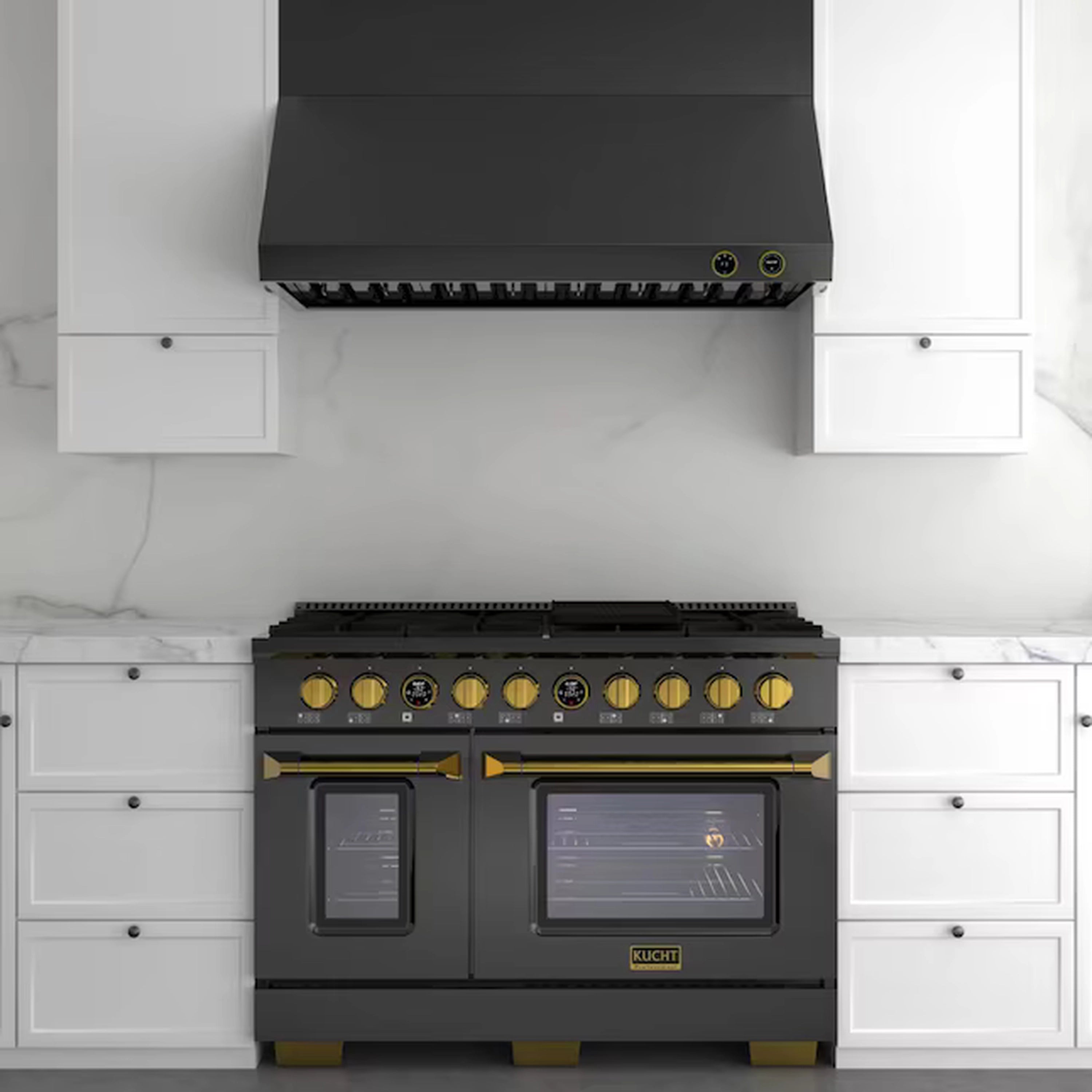 Wall-mounted ducted range hood above a black cooktop, with gold-trimmed controls