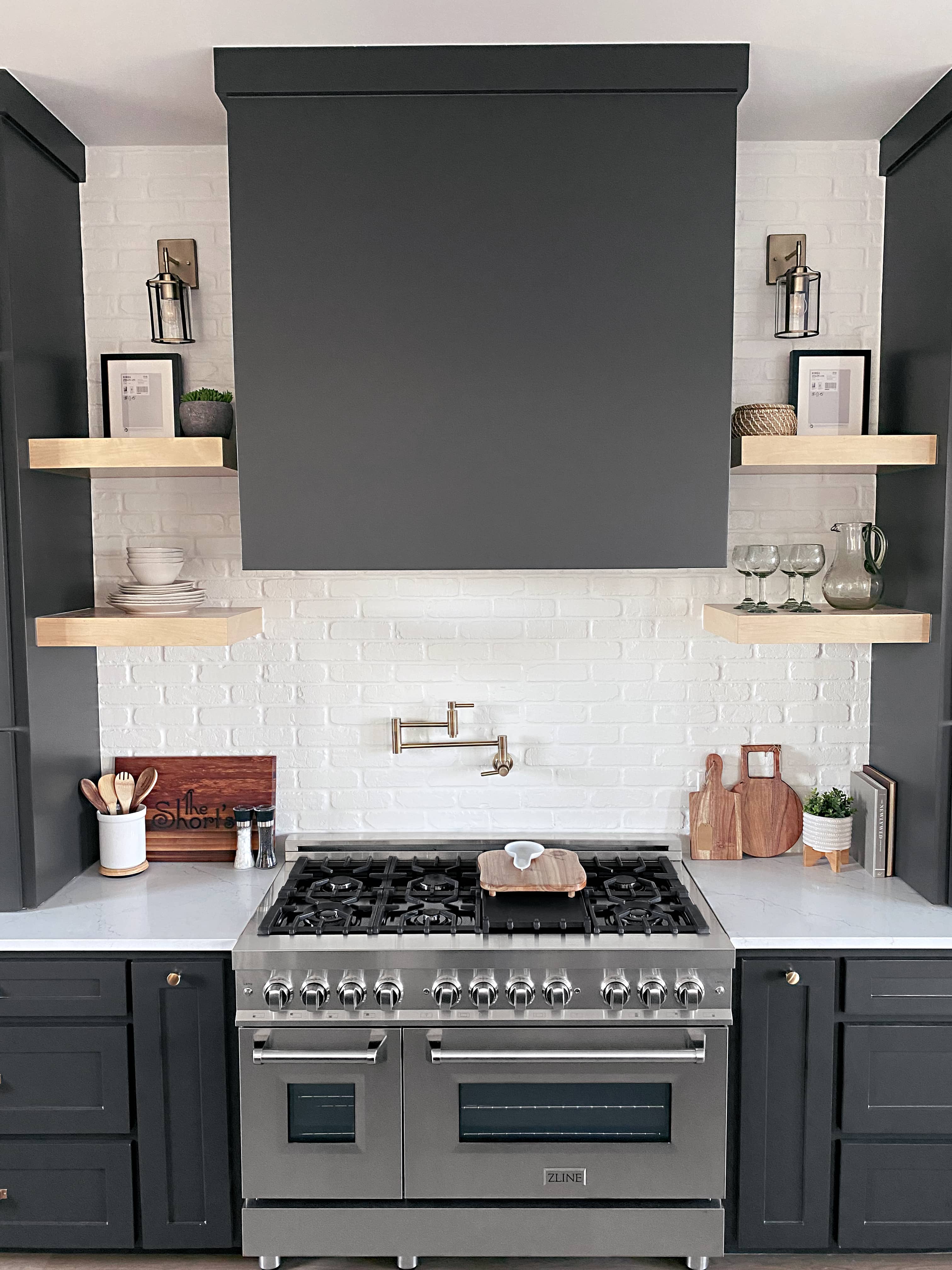 Stainless steel dual-fuel range with black cooktop grates and control knobs