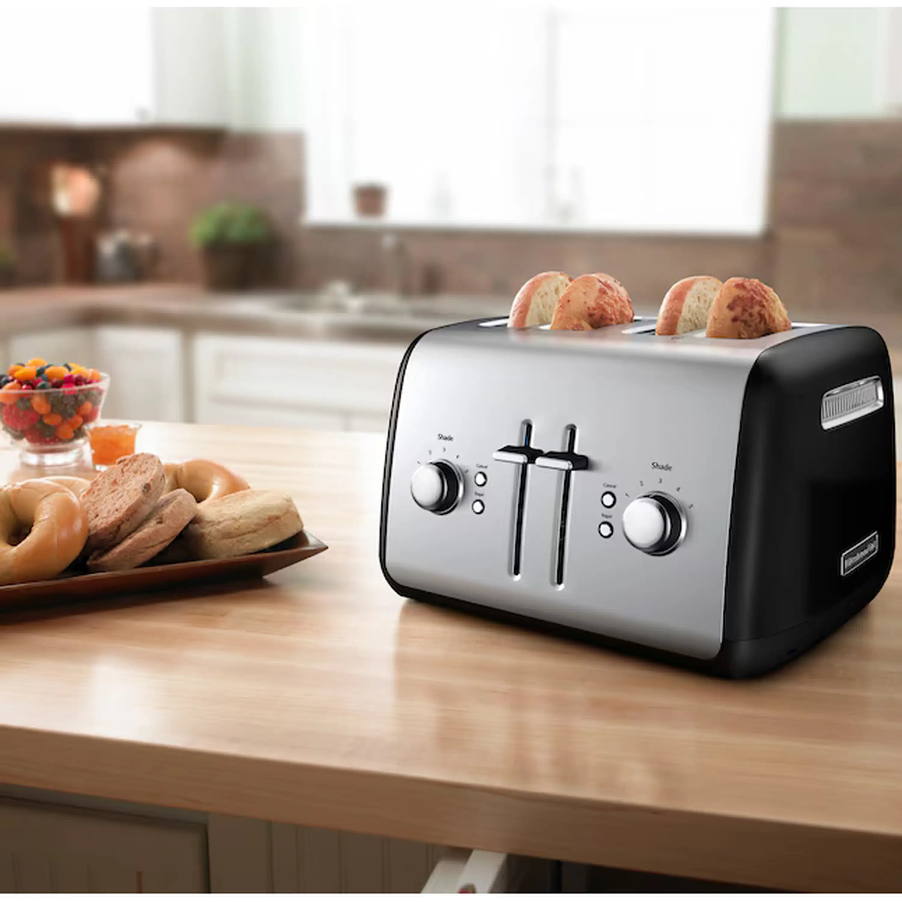 Brushed-metal 4-slice toaster with black sides, manual levers, bread on top