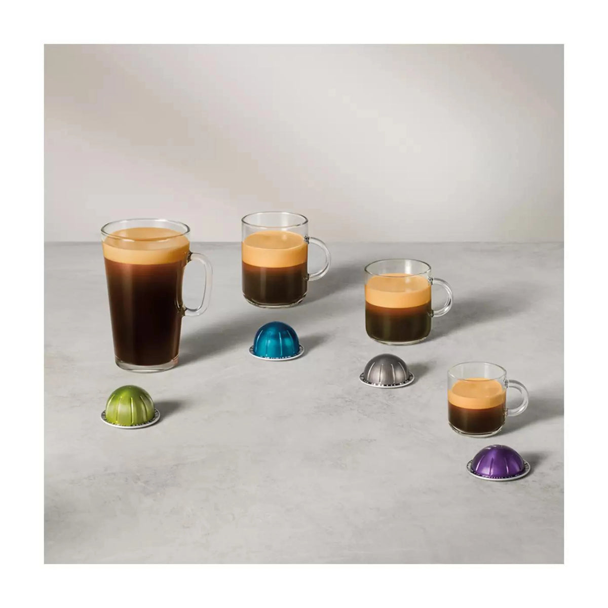 Nespresso capsules and brewed espresso cups with assorted pod color caps
