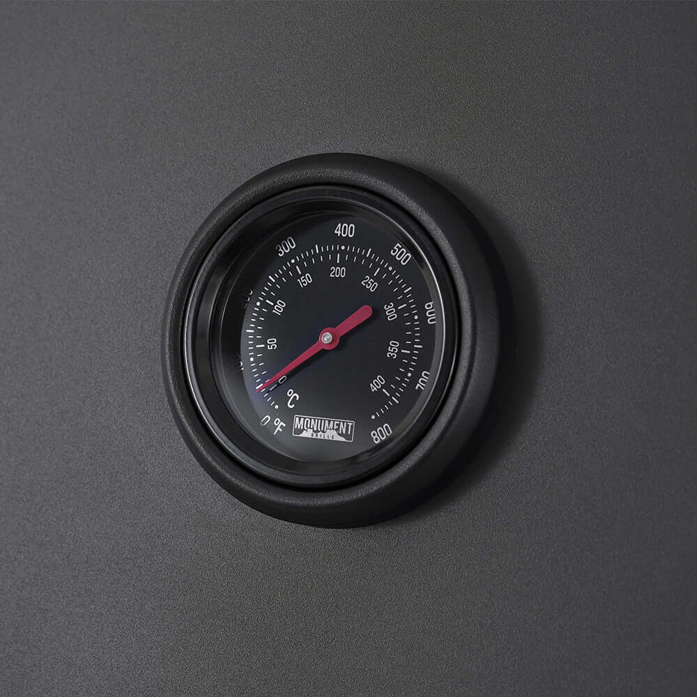 Close-up of grill lid thermometer gauge with temperature markings