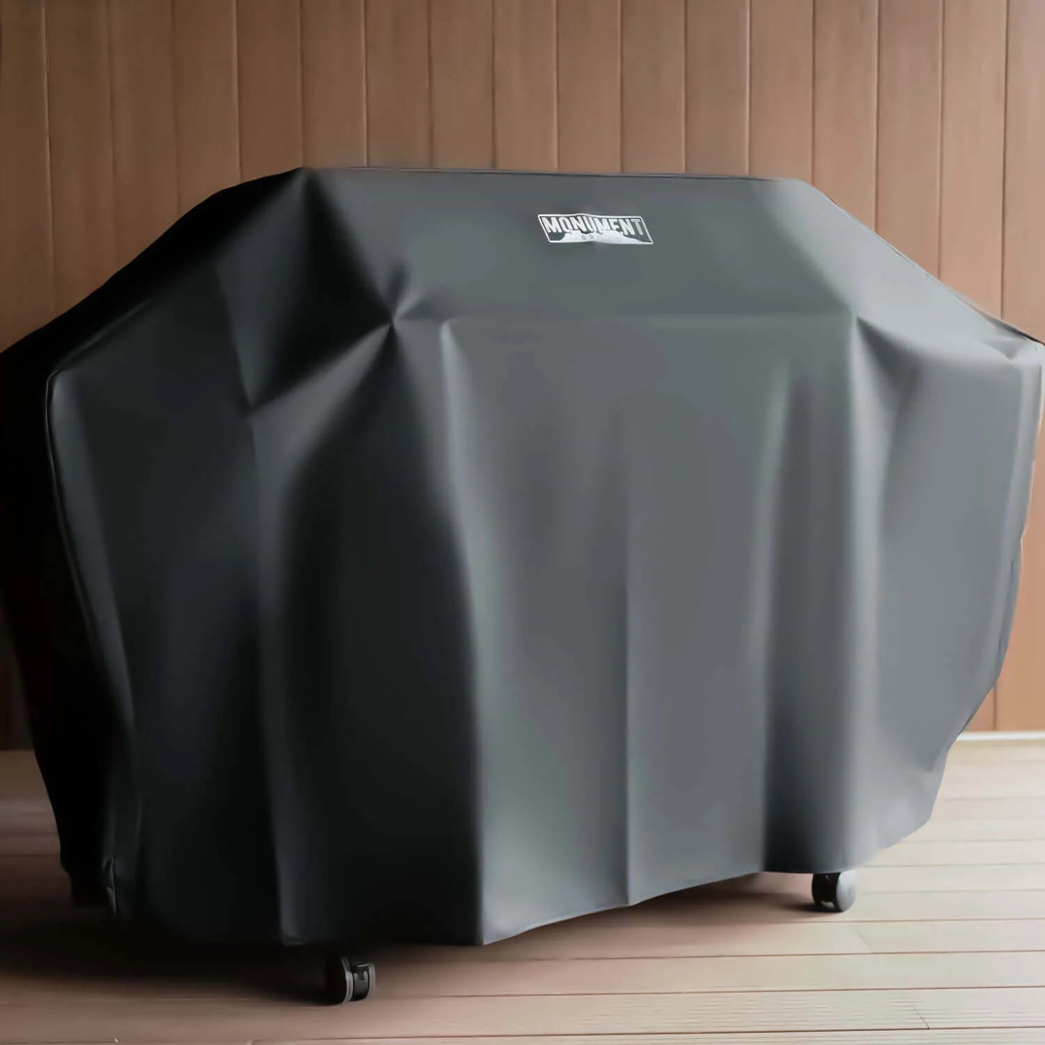 Stainless propane gas grill covered with a fitted protective grill cover