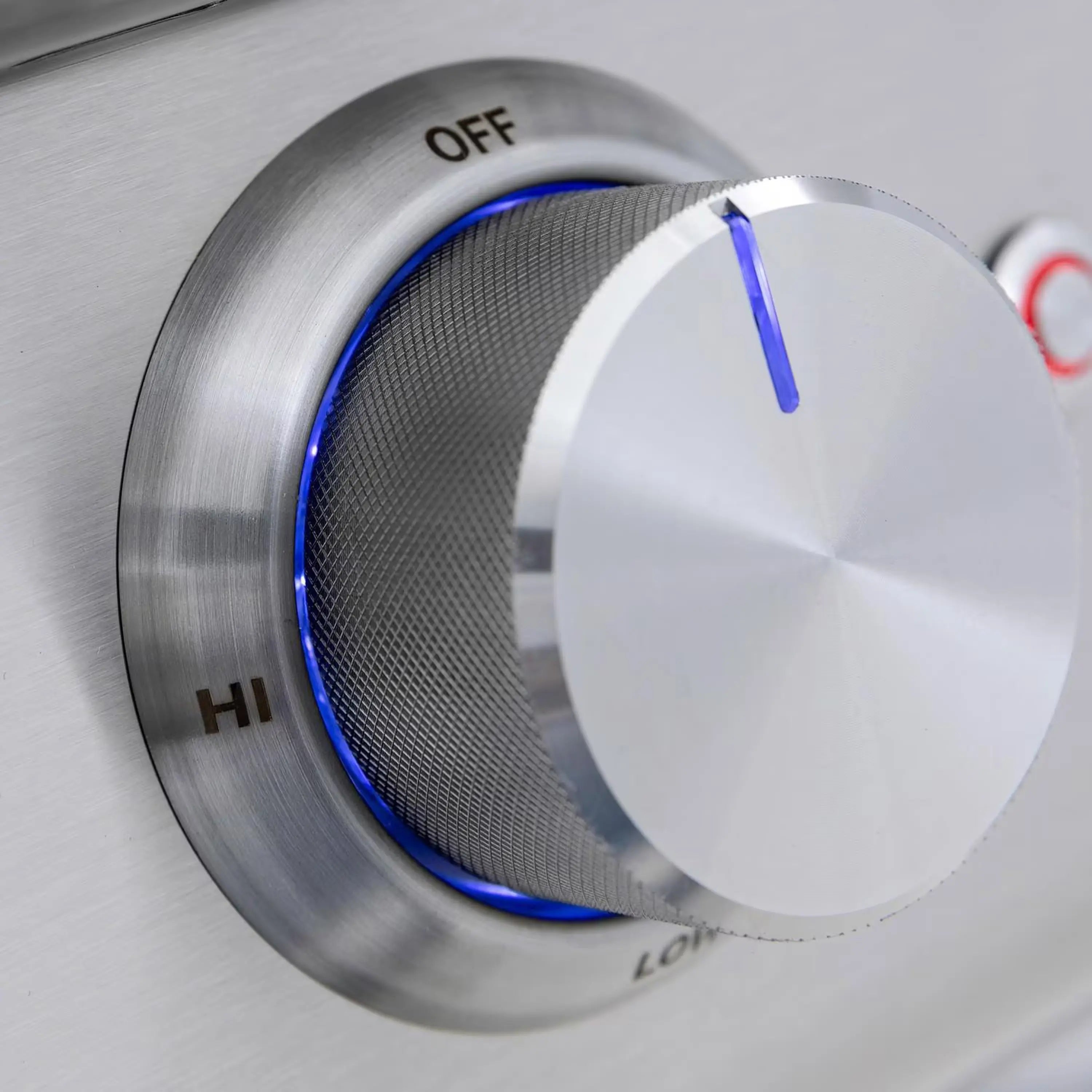 Stainless grill control knob set near OFF with blue indicator light
