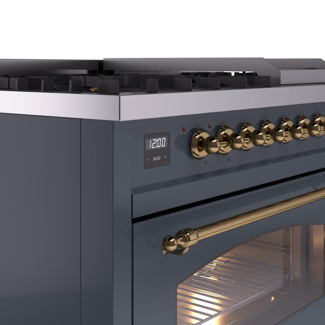 Dual fuel range cooktop control area with brass knobs and lit oven door window.