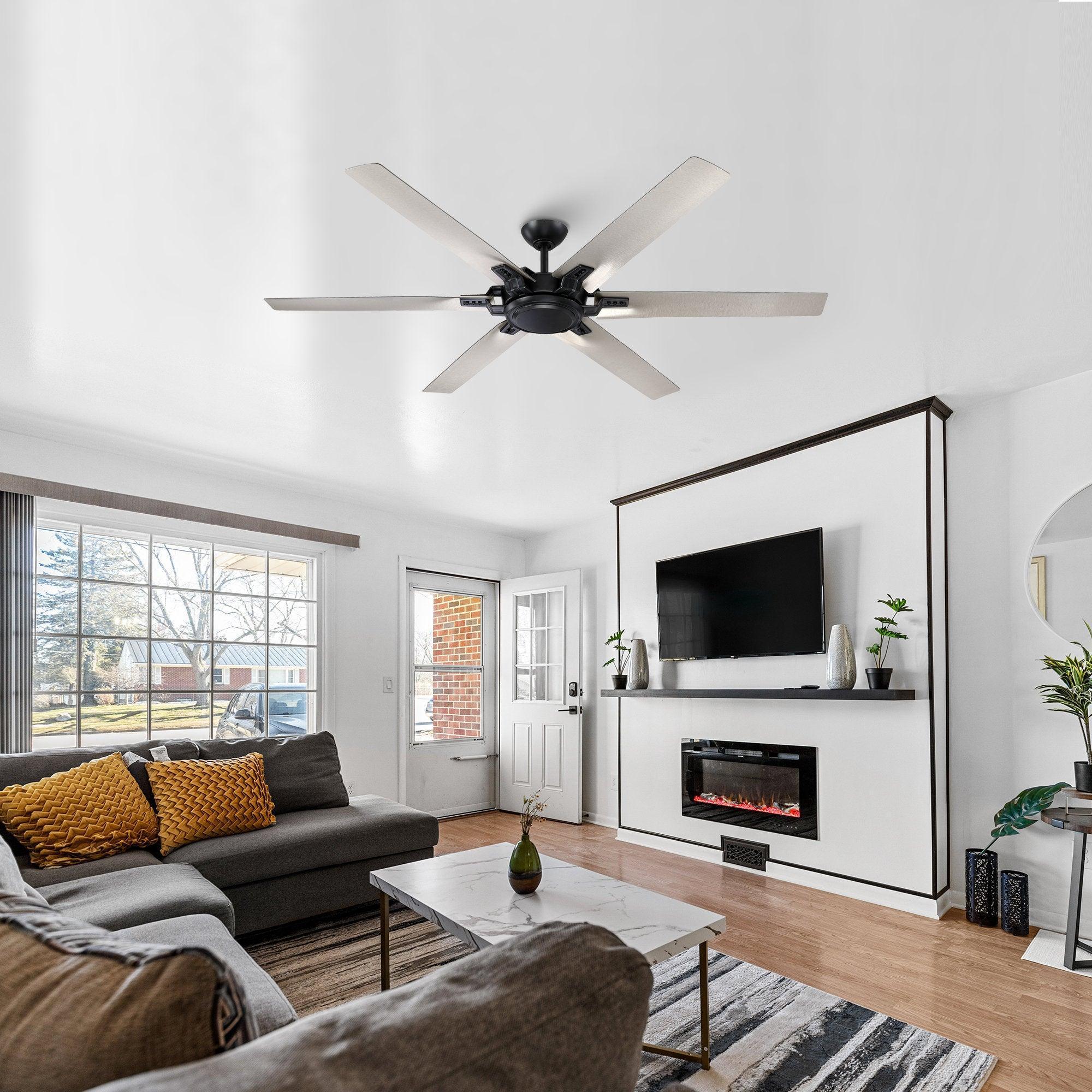 Black ceiling fan with five light wood-toned blades installed in a living room ceiling