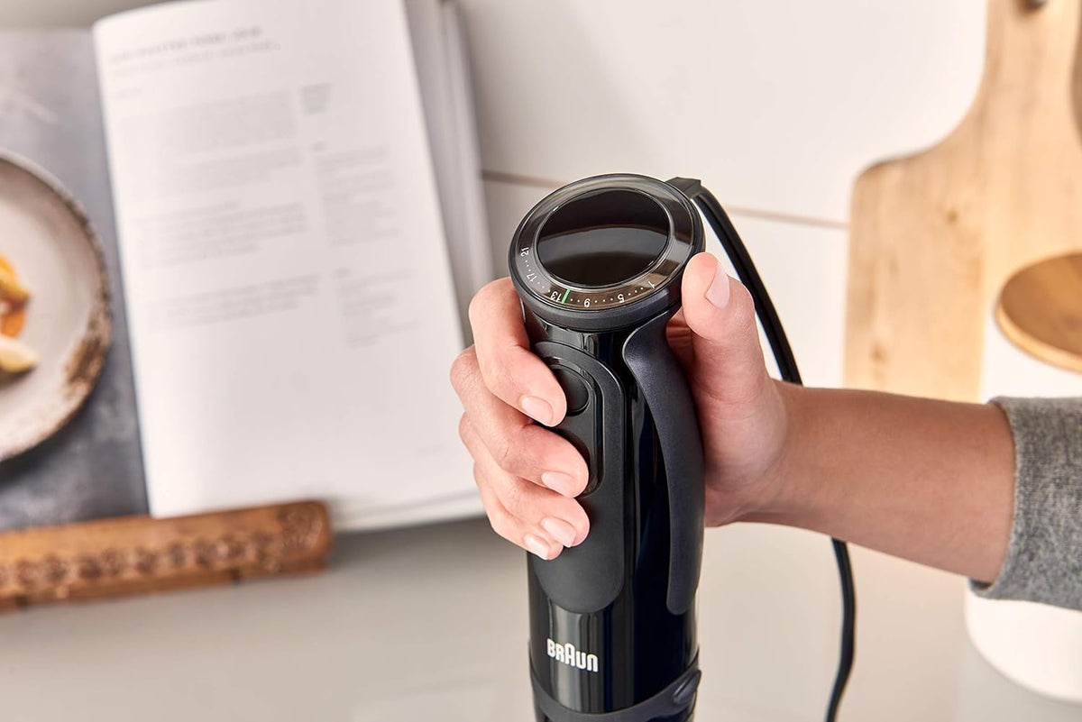 Black Braun immersion blender held upright by the grip with power cord attached