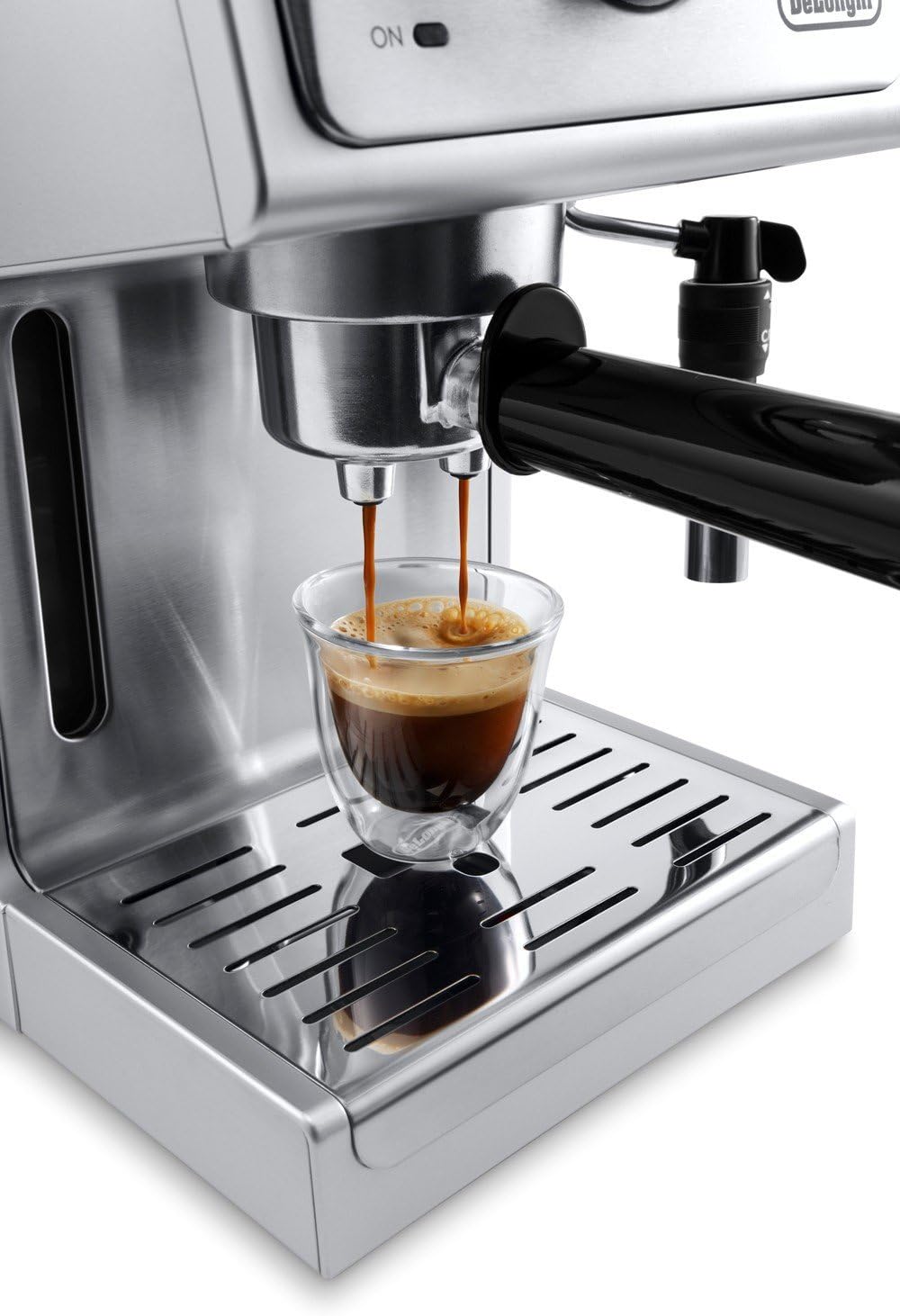 De'Longhi brewing spout pouring espresso into a single clear cup