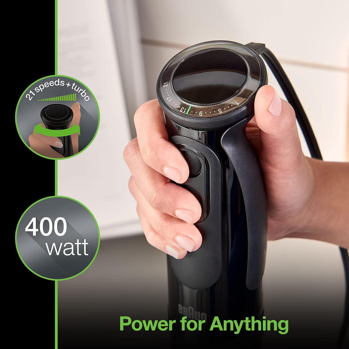 Black handheld immersion blender with speed dial, gripped in a user’s hand