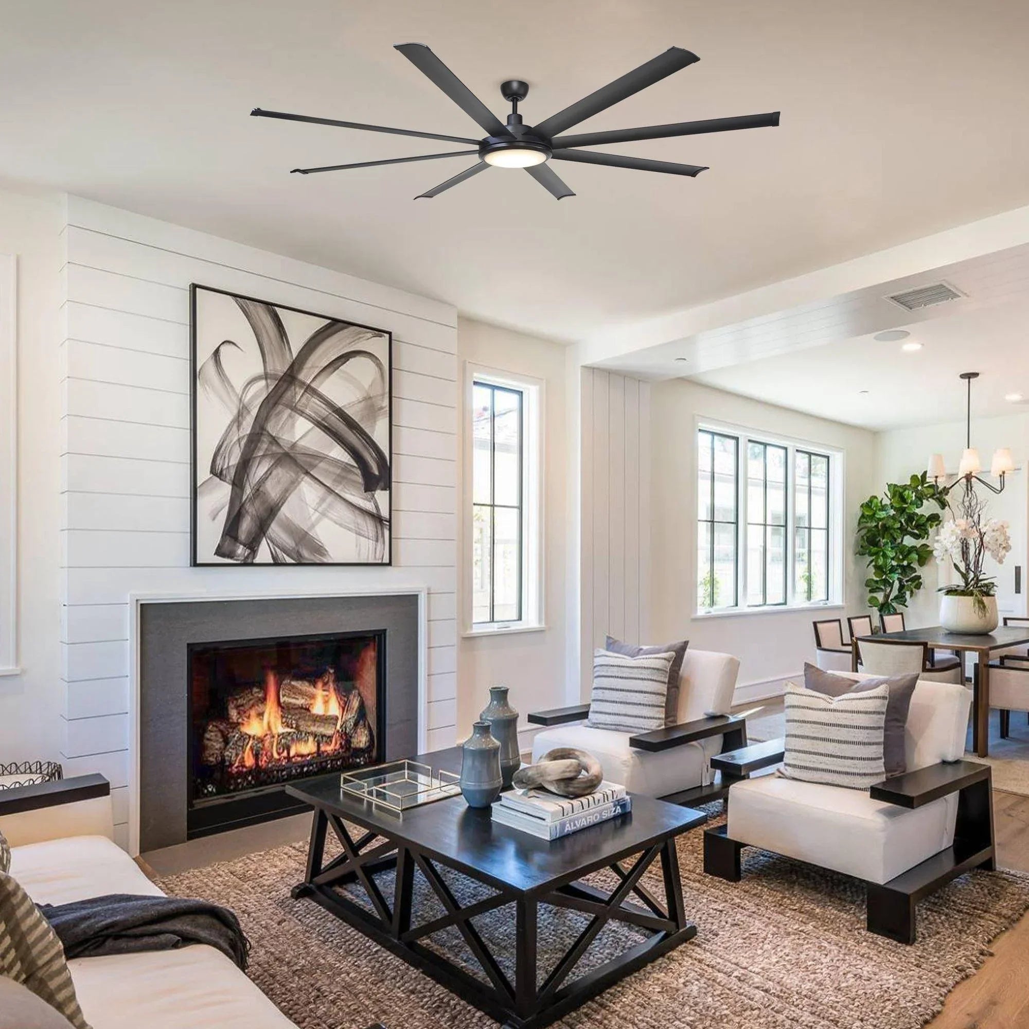 Black ceiling fan with integrated light above a fireplace and seating area