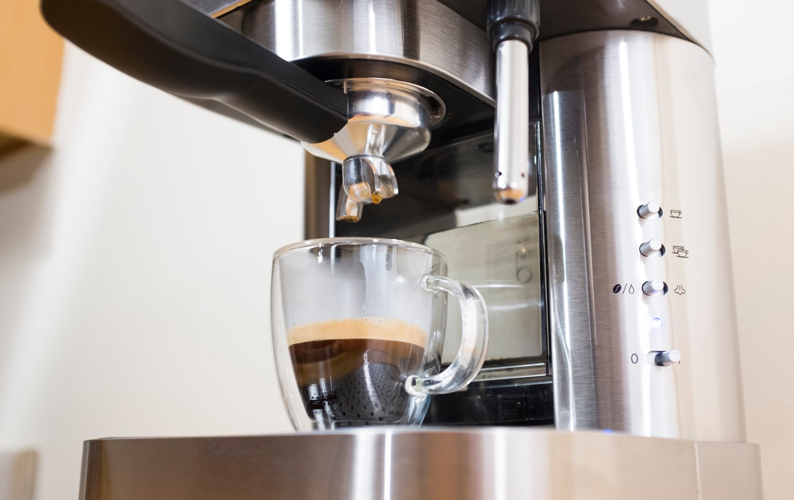 Espressione stainless steel espresso machine pouring espresso into glass cup