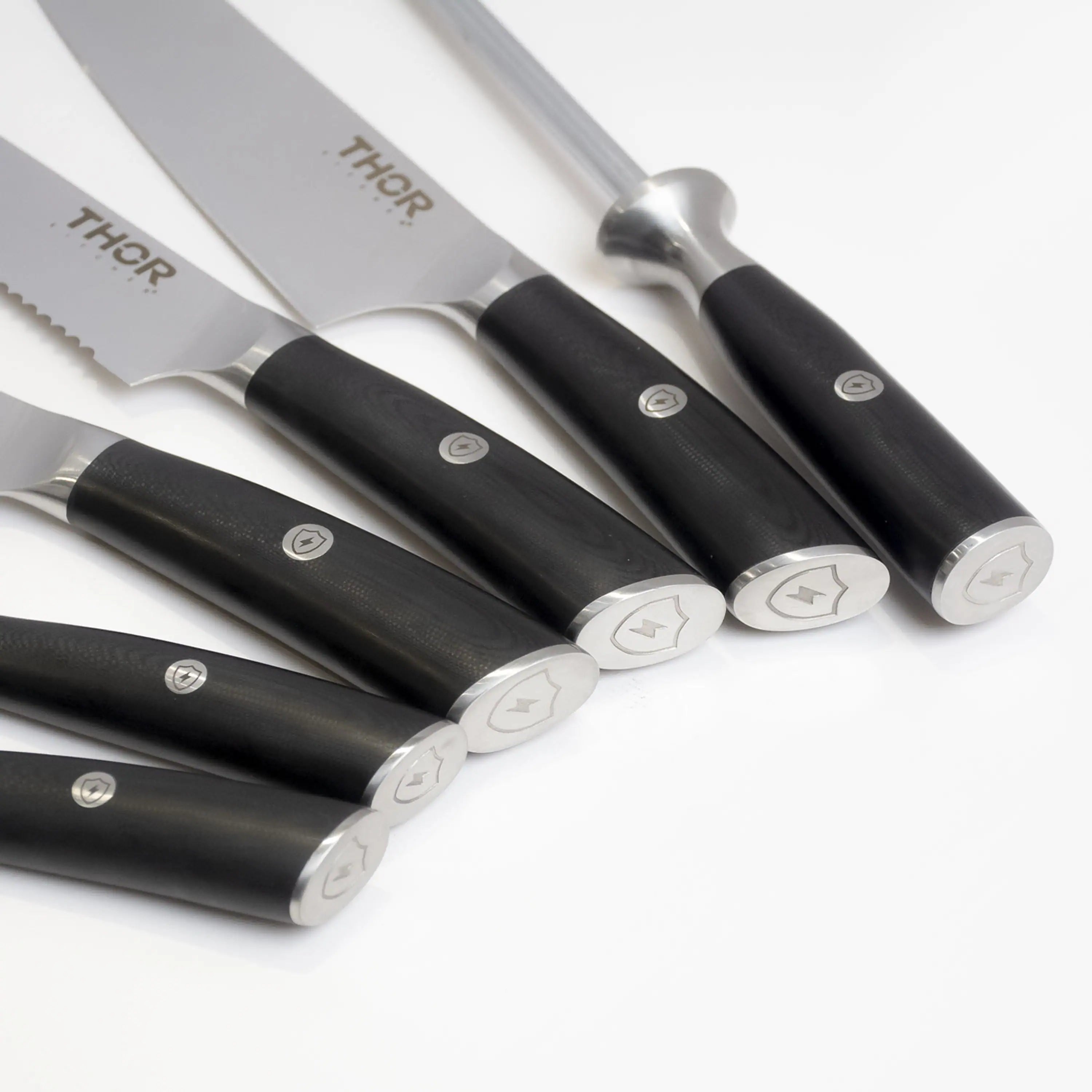Assorted knives with black handles and stainless blades in a tight cluster