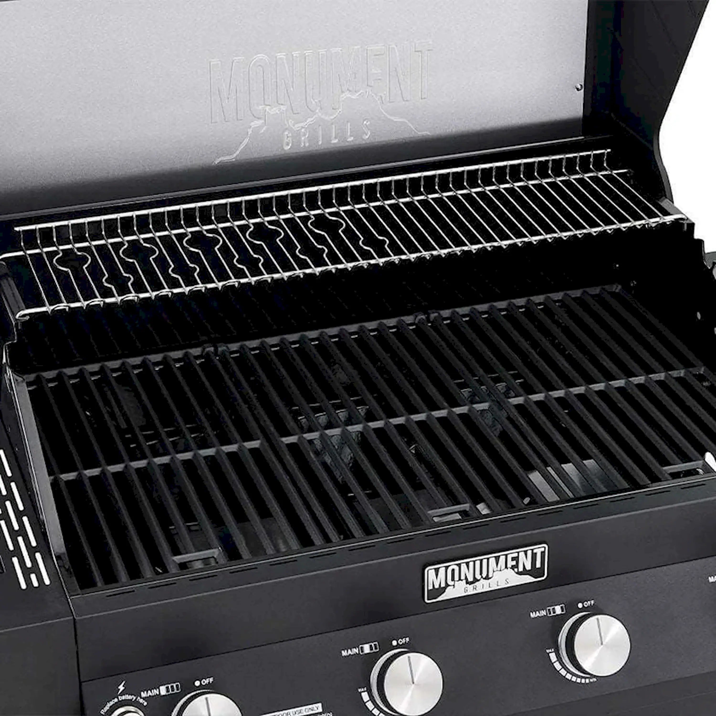 Black gas grill lid open with stainless cooking grates and warming rack
