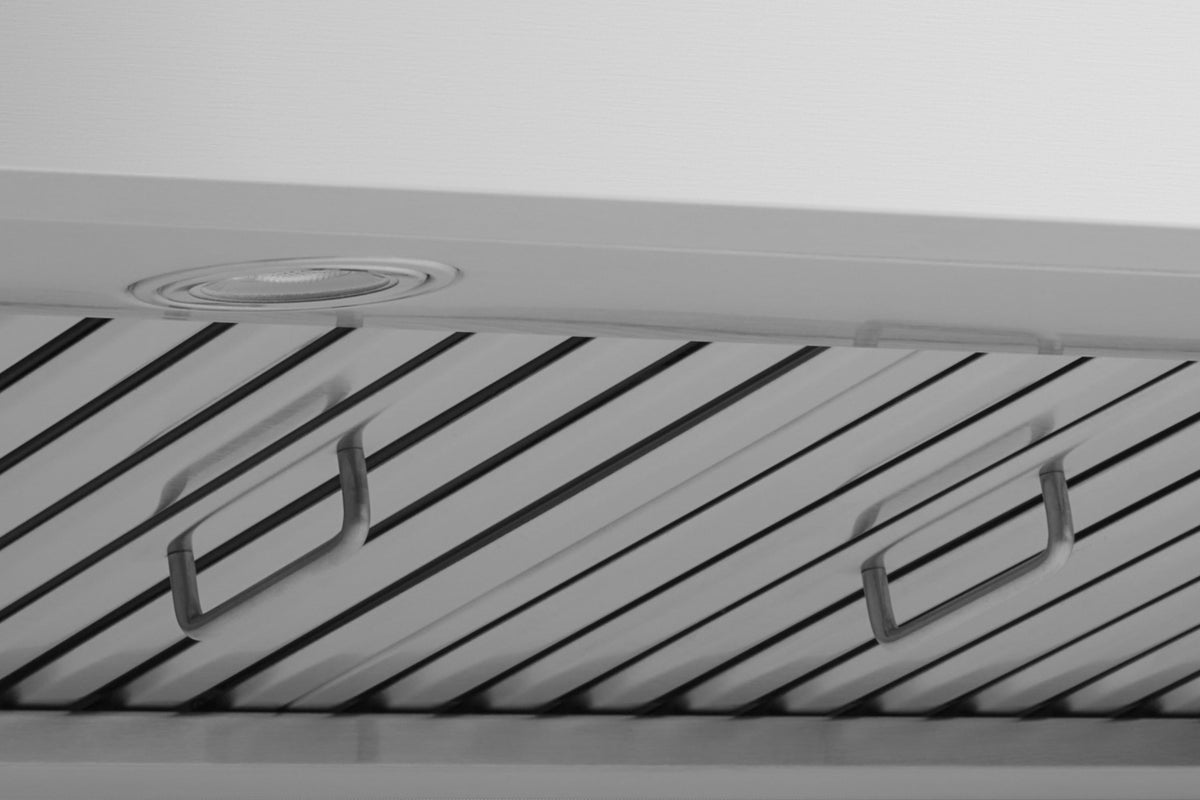 Close-up of stainless steel hood baffle filters and metal support bars.